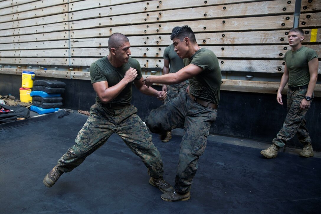 GULF OF ADEN (Oct. 17, 2015) U.S Marine Sgt. Marcos Gonzalez, left, spars with Lance Cpl. Giovanni Carrera during the combat conditioning portion of a Marine Corps Martial Arts Program black belt course aboard the USS Rushmore (LSD 47). Gonzalez is a motor transportation operator with Combat Logistics Battalion 15, 15th Marine Expeditionary Unit. Carrera is an amphibious assault vehicle crewman with Kilo Company, Battalion Landing Team 3rd Battalion, 1st Marine Regiment, 15th MEU. In addition enhancing hand-to-hand combat skills, MCMAP sharpens the decision making and mental toughness of the Marines by instilling a warrior ethos.. (U.S. Marine Corps photo by Sgt. Emmanuel Ramos/Released)