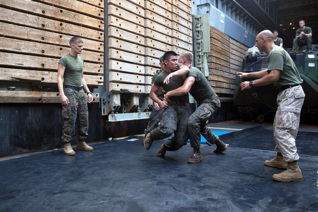 GULF OF ADEN  (Oct. 17, 2015) U.S Marine Lance Cpl Giovanni Carrera, right, spars with Cpl. Shawn Obrien during the combat conditioning portion of a Marine Corps Martial Arts Program black belt course aboard the USS Rushmore (LSD 47). Obrien is an amphibious assault vehicle crew chief and Carrera is an AAV crewman, both with Kilo Company, Battalion Landing Team 3rd Battalion, 1st Marine Regiment, 15th MEU. In addition enhancing hand-to-hand combat skills, MCMAP sharpens the decision making and mental toughness of the Marines by instilling a warrior ethos. (U.S. Marine Corps photo by Sgt. Emmanuel Ramos/Released)