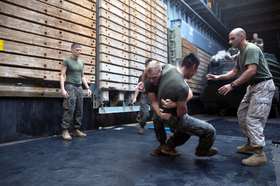 GULF OF ADEN  (Oct. 17, 2015) U.S Marine Lance Cpl Giovanni Carrera, right, spars with Cpl. Shawn Obrien during the combat conditioning portion of a Marine Corps Martial Arts Program black belt course aboard the USS Rushmore (LSD 47). Obrien is an amphibious assault vehicle crew chief and Carrera is an AAV crewman, both with Kilo Company, Battalion Landing Team 3rd Battalion, 1st Marine Regiment, 15th MEU. In addition enhancing hand-to-hand combat skills, MCMAP sharpens the decision making and mental toughness of the Marines by instilling a warrior ethos.. (U.S. Marine Corps photo by Sgt. Emmanuel Ramos/Released)