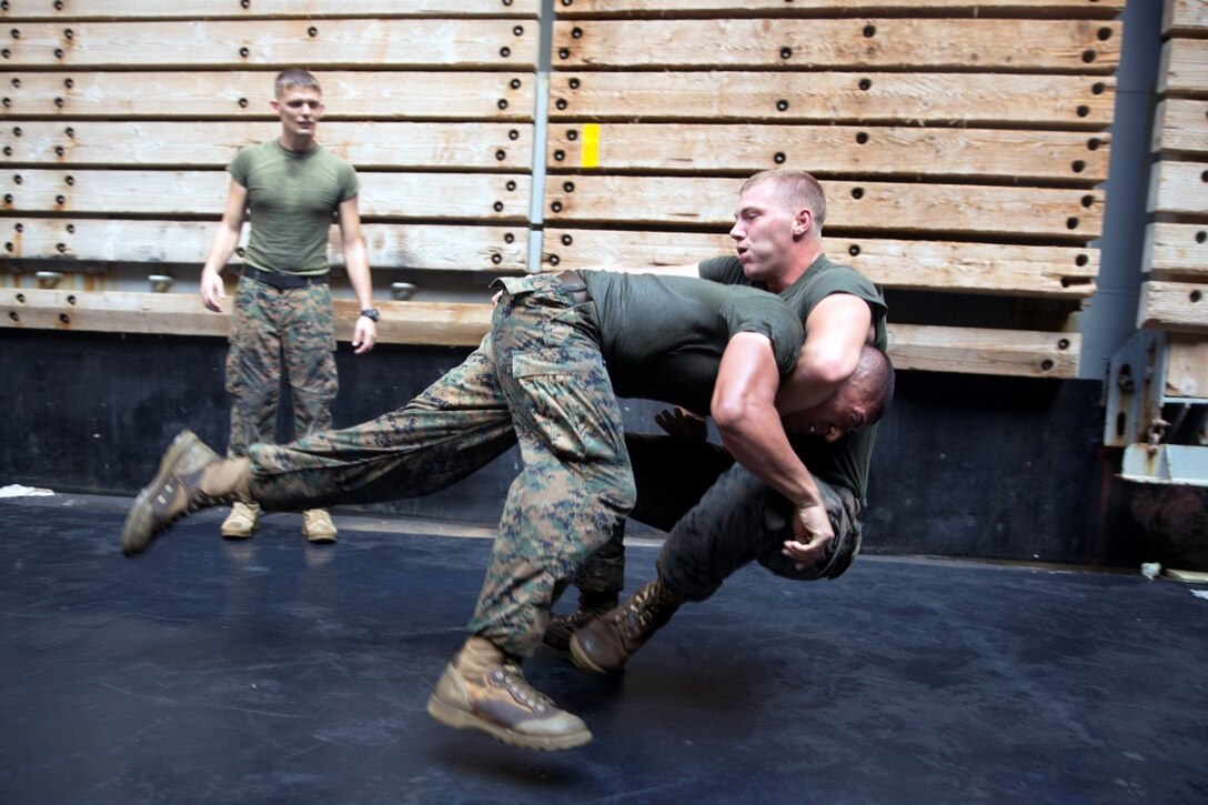GULF OF ADEN  (Oct. 17, 2015) U.S Marine Cpl. Shawn Obrien, left, takes down Sgt. Marcos Gonzalez during the combat conditioning portion of a Marine Corps Martial Arts Program black belt course aboard the USS Rushmore (LSD 47). Gonzalez is a motor transportation operator with Combat Logistics Battalion 15, 15th Marine Expeditionary Unit. Obrien is an amphibious assault vehicle crew chief with Kilo Company, Battalion Landing Team 3rd Battalion, 1st Marine Regiment, 15th MEU. In addition enhancing hand-to-hand combat skills, MCMAP sharpens the decision making and mental toughness of the Marines by instilling a warrior ethos. (U.S. Marine Corps photo by Sgt. Emmanuel Ramos/Released)
