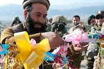 Wasir Kahn, an Afghan Malik and village elder, cuts the ceremonial ribbon during the opening of a new marketplace near Gerdy Katz, Dec. 3, 2011. The market is only the most recent, albeit essential, addition to a list of achievements the Kansas National Guard's Agribusiness Development Team and their Afghan counterparts have struggled to reach together.