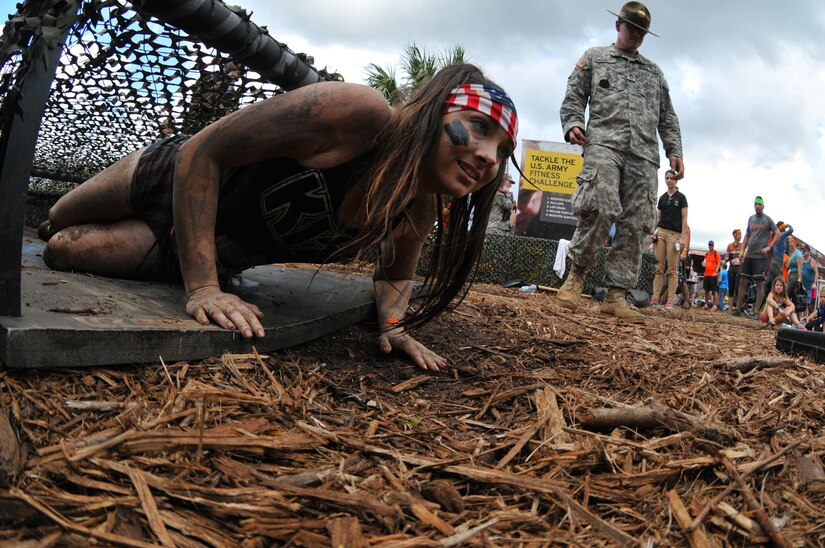 Ashley Hayes an Orange Park, Fla., native, crawls through an obstacle while racing through the Army Reserve Fitness Challenge during day one of the 2015 Tough Mudder at Palm Bay Fla., Nov. 8. A team of drill sergeants was present motivating and critiquing the participants as they took on the challenge. The drill sergeants guaranteed that competitors got a feel of how it’s like working under stress and urgency by yelling commands and creating a stressful environment while ensuring the competitors navigated the course using proper Army technique. The timed challenge was comprised of five Army themed exercises in which volunteers competed for prizes and spots on the daily leaderboard.
