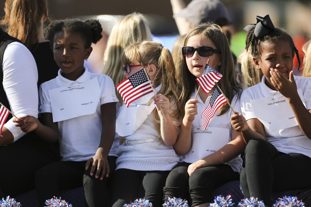 Children wave American flags from a float during the 20th Annual Veterans Day Parade in Jacksonville, N.C., Nov. 7, 2015. The  parade, hosted by Rolling Thunder, allowed veterans, service members and residents of Jacksonville to show support for members of the armed forces. U.S. Marine Corps photo by Staff Sgt. Neill A. Sevelius