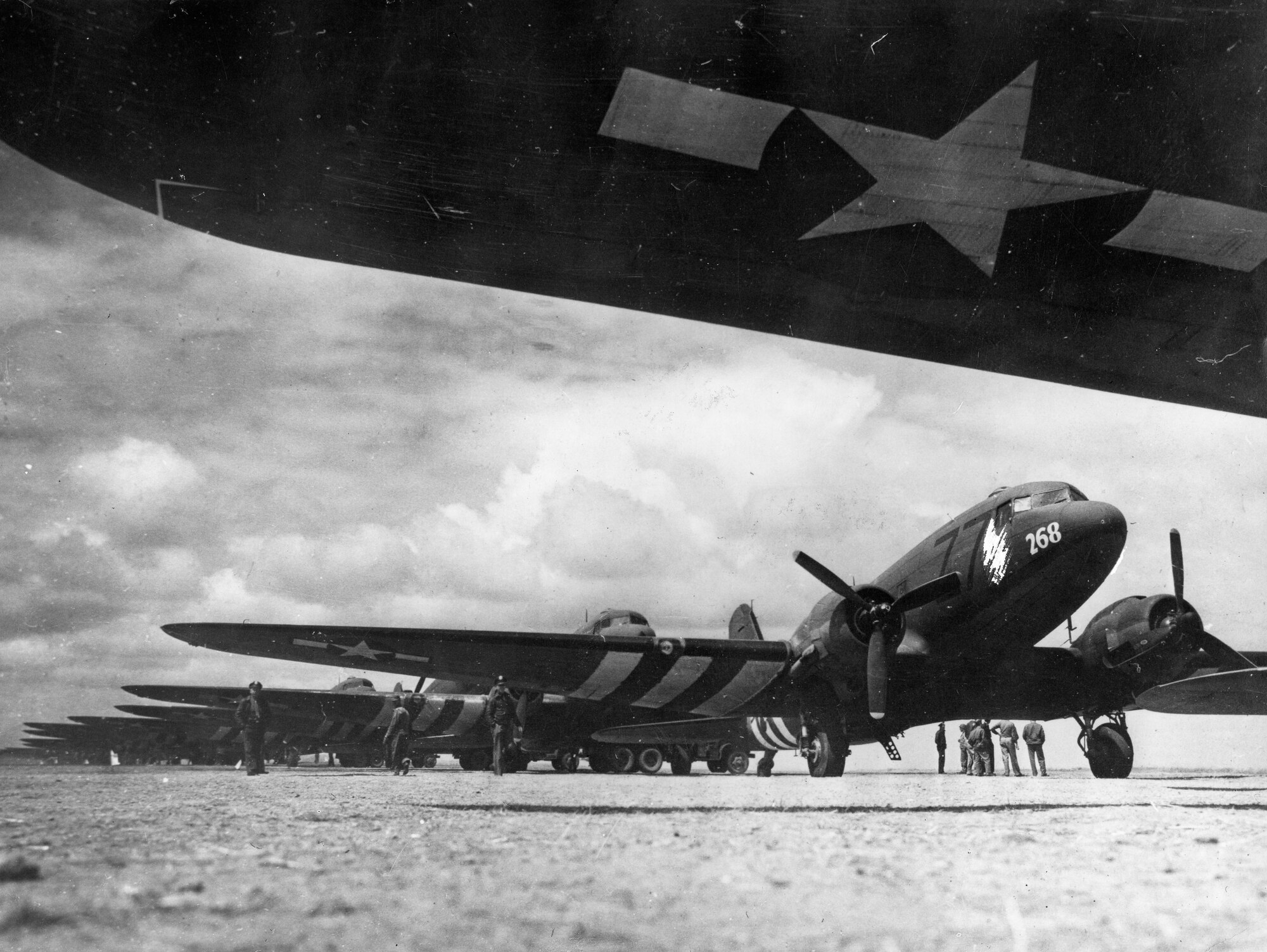 Planes carrying wounded soldiers prepare to take off from a landing strip in France. Notice the black and white stripes on the wings, known as “D-Day Stripes.” They were painted on all tactical aircraft after June 6, 1944 to prevent friendly fire incidents.