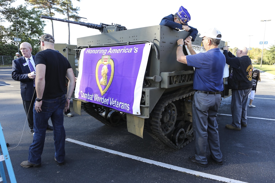 Veterans with Beirut Memorial Chapter 642 place signs on an M3 personnel half-track carrier before the 20th Annual Veterans Day Parade in Jacksonville, N.C., Nov. 7, 2015. The parade, hosted by Rolling Thunder, allowed veterans, service members and the residents of Jacksonville to show support for members of the armed forces. U.S. Marine Corps photo by Staff Sgt. Neill A. Sevelius