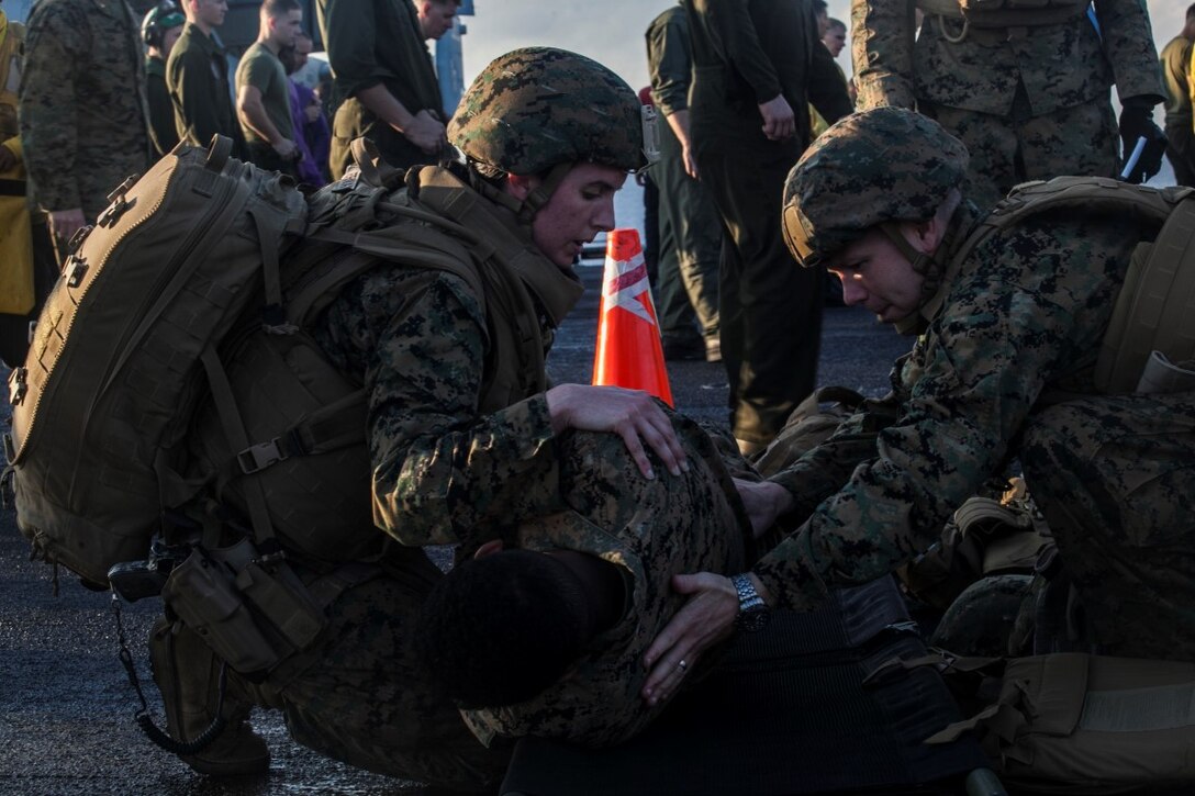 INDIAN OCEAN (Nov. 4, 2015) Navy Lt. Katherine Gervais, left, and Lt. Cdr. Brian Dimmer with tend to a simulated causality during a mass-casualty drill on the flight deck of the USS Essex (LHD 2). Gervais is a en-route care nurse assigned to Combat Logistics Battalion 15, and Dimmer is the 15th Marine Expeditionary Unit surgeon. The Marines and Sailors honed their skills to become quicker and more efficient should a situation arise where medical attention is needed. The 15th MEU is currently deployed in the Indo-Asia-Pacific region to promote regional stability and security in the U.S. 7th Fleet area of operations. (U.S. Marine Corps photo by Cpl. Elize McKelvey/Released)