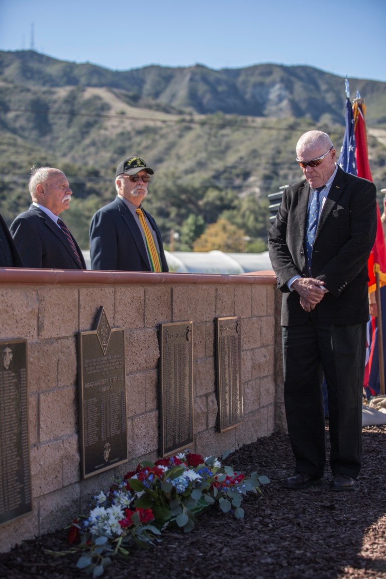 On Nov. 6, 2015, aboard Marine Corps Base Camp Pendleton, Calif., Paul Mangan, the president of the Vietnam Veterans of 2nd Battalion, 1st Marine Regiment, places flowers below plaques newly dedicated to members of the regiment who gave their lives during the Vietnam War. The plaques were dedicated during a ceremony attended by past and present members of the regiment at the Camp Horno Memorial Garden. (U.S. Marine Corps photo by Lance Cpl. Alvin Pujols/Released)