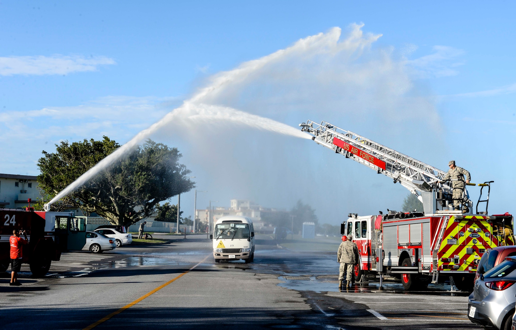 U.S. Air Force firefighters from the 18th Civil Engineer Squadron spray a water arch over a bus filled with Kadena Special Olympics athletes as they arrive at the Risner Fitness Center Sports Complex Nov. 7, 2015, at Kadena Air Base, Japan. The KSO began in 2000 with approximately 400 athletes and 600 volunteers as an 18th Wing community goodwill initiative to strengthen U.S. - Okinawa relationships. After 16 years, the event has more than doubled in size and participation. (U.S. Air Force photo by Senior Airman John Linzmeier/Released) 