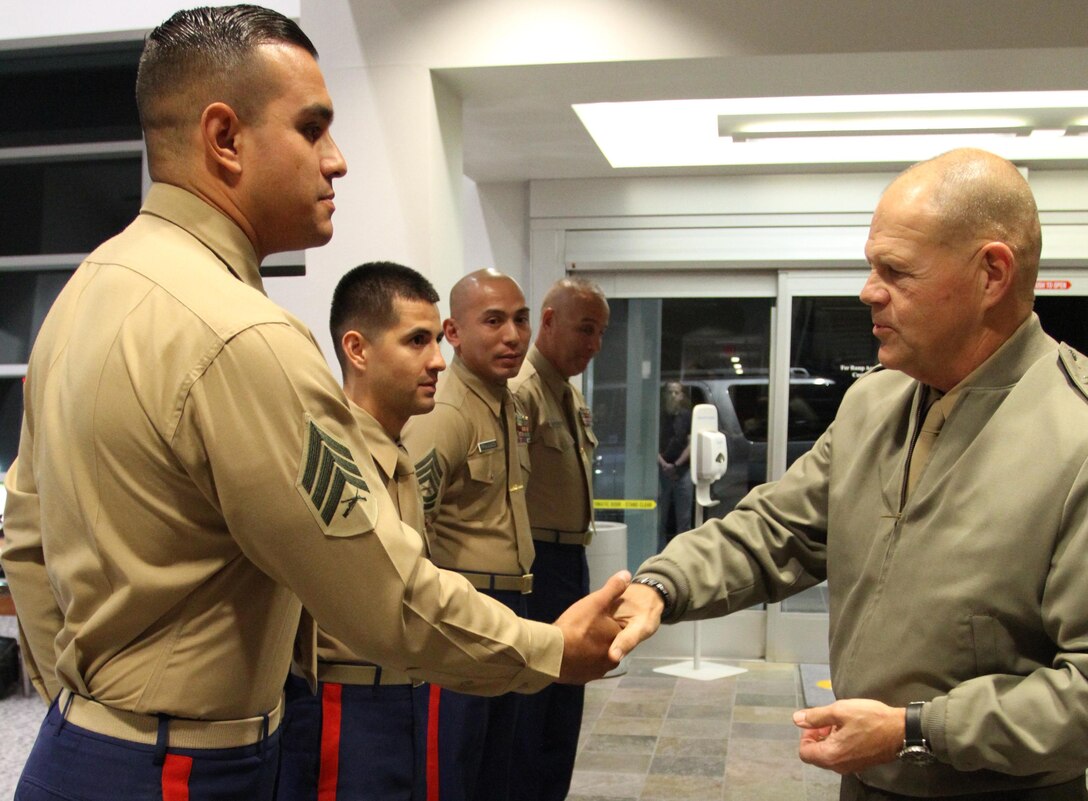 Commandant of the Marine Corps, Gen. Robert B. Neller, presents Sgt. Jose Morales, recruiter from Recruiting Sub Station Downey, with his challenge coin, Nov. 6, 2015, after winning rookie recruiter of Recruiting Station Los Angeles. The commandant flew in to Los Angeles to attend the Reagan National Defense Forum, and upon landing at the Camarillo airport, he recognized the Marines for their hard work and dedication in recruiting efforts. (U.S. Marine Corps photo by Sgt. Alicia R. Leaders/Released)
