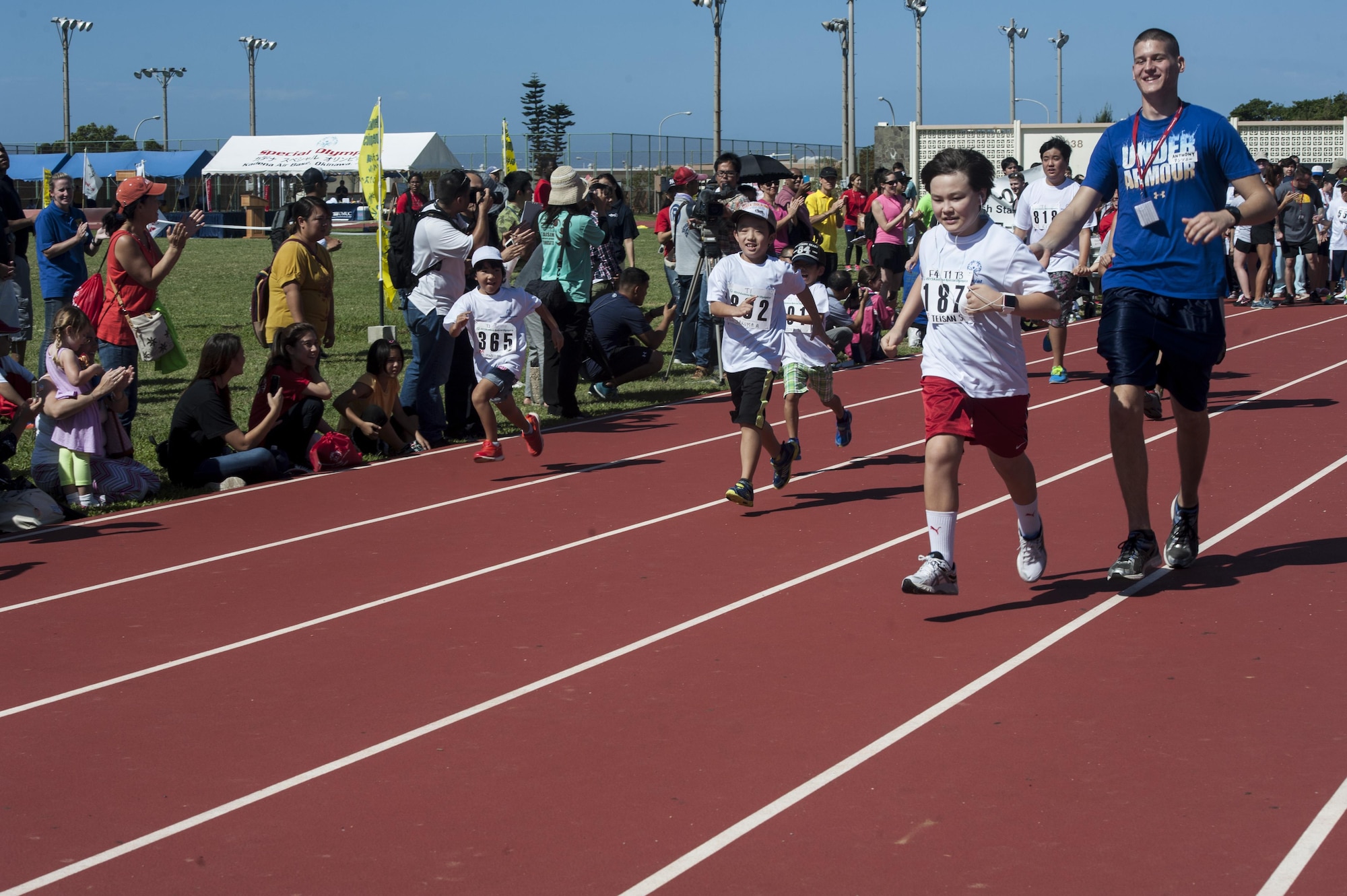 U.S. Air Force Airman 1st Class Anthony Sojka, 18th Component Maintenance Squadron aerospace propulsion apprentice, runs with Teisan Scarborough, a Kadena Special Olympics athlete, during the Kadena Special Olympics Nov. 7, 2015, at Kadena Air Base, Japan. Approximately 1700 volunteers helped nearly 900 athletes arrive to their events and compete in the largest overseas Special Olympics in the world. (U.S. Air Force photo by Airman 1st Class Lynette M. Rolen/Released)