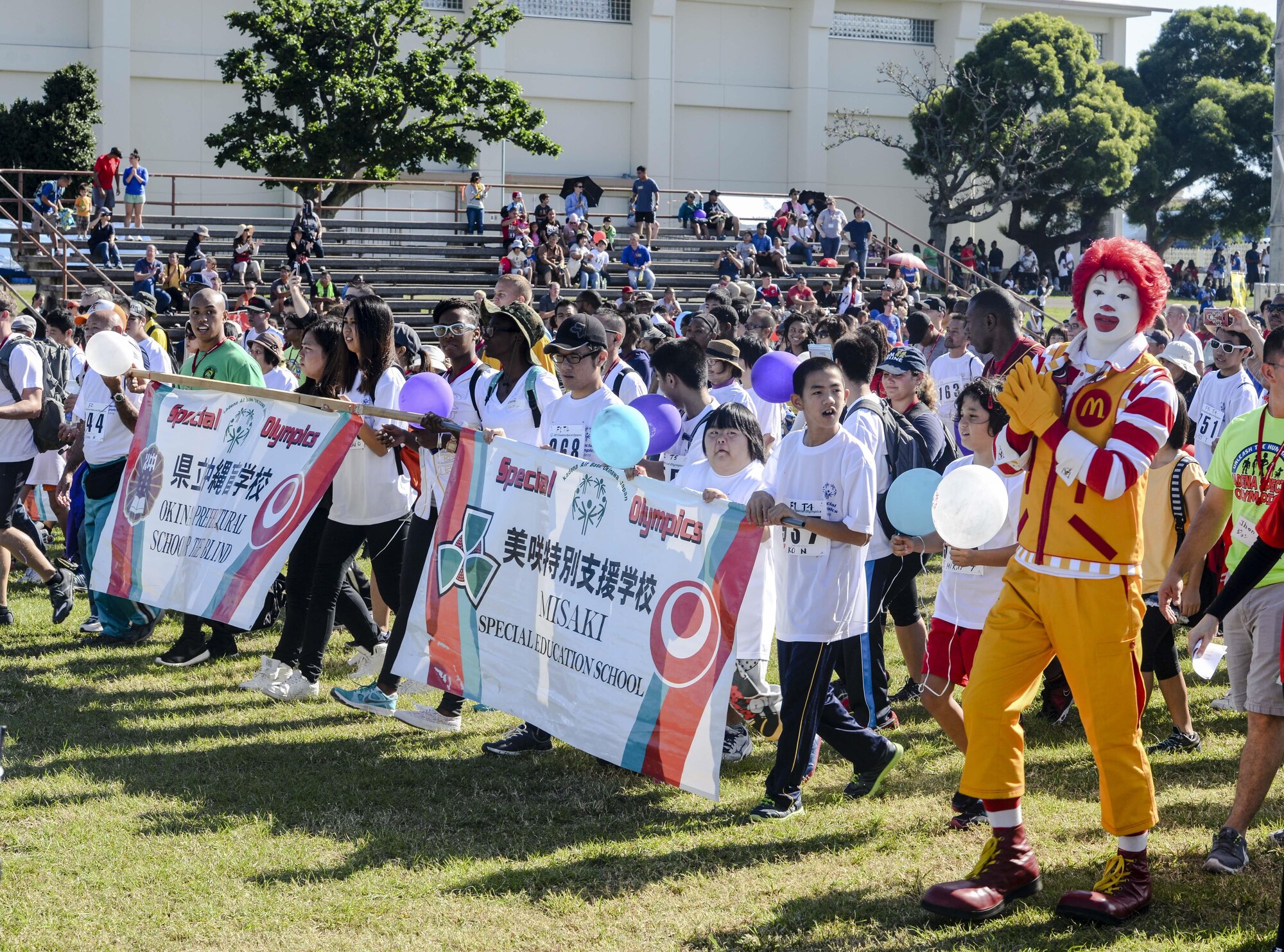 Participants and volunteers of the Kadena Special Olympics parade down the Risner Fitness Center field during the event’s opening ceremony Nov. 7, 2015, at Kadena Air Base, Japan. KSO is a non-profit activity managed by volunteers from around the island and funded by donations as a goodwill initiative to give back to those with special needs. (U.S. Air Force photo by Senior Airman John Linzmeier/Released) 