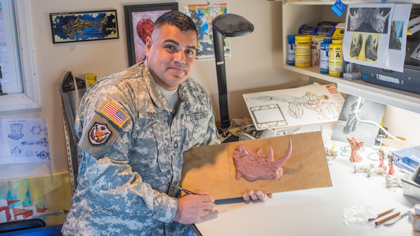 Sgt. 1st Class Pedro Rios, 311th Theater Signal Command, Costa Mesa, Calif., holds a work of art in progress. Rios has created a unique body of work by sculpting a fantasy creature he cast in plastic resin.