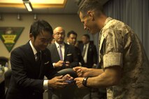 Daisuke Haneshiro, left, exchanges business cards with Lt. Col. James J. Hurd during a visit and educational tour October 14 on Marine Corps Air Station Futenma. During the visit, chairmen of the Japan-Russia Friendship Association were instructed on the history and tenant units of MCAS Futenma. After a question and answer session, Marine officials provided the chairmen with a windshield tour of the air station. Haneshiro is a chairman with the Japan-Russia Friendship Association. Hurd is the executive officer of MCAS Futenma, Marine Corps Installations Pacific and a Kingston, New Hampshire, native.