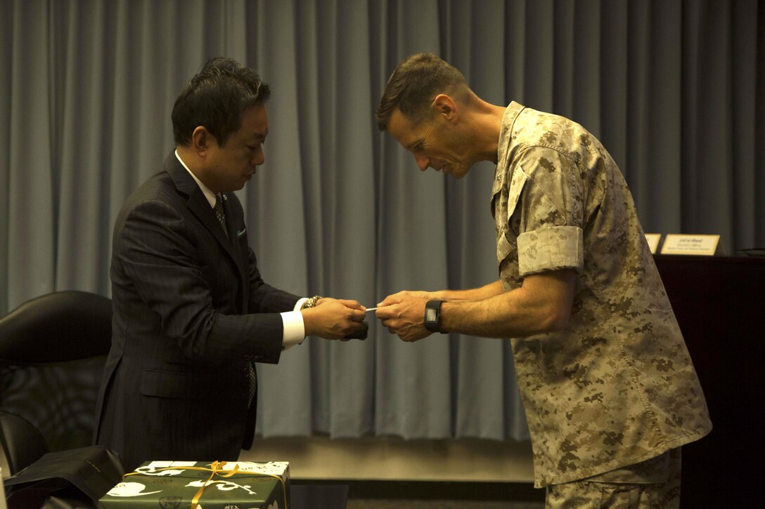 Masaoki Fukui, left, exchanges business cards with Lt. Col. James J. Hurd during a visit and educational tour October 14 on Marine Corps Air Station Futenma. During the visit, chairmen of the Japan-Russia Friendship Association were informed about the history and tenant units of MCAS Futenma and their capabilities. After a question and answer session, the guests boarded a bus for a windshield tour of the installation. Fukui is a chairman with the Japan-Russia Friendship Association. Hurd is the executive officer of MCAS Futenma, Marine Corps Installations Pacific and a Kingston, New Hampshire, native.