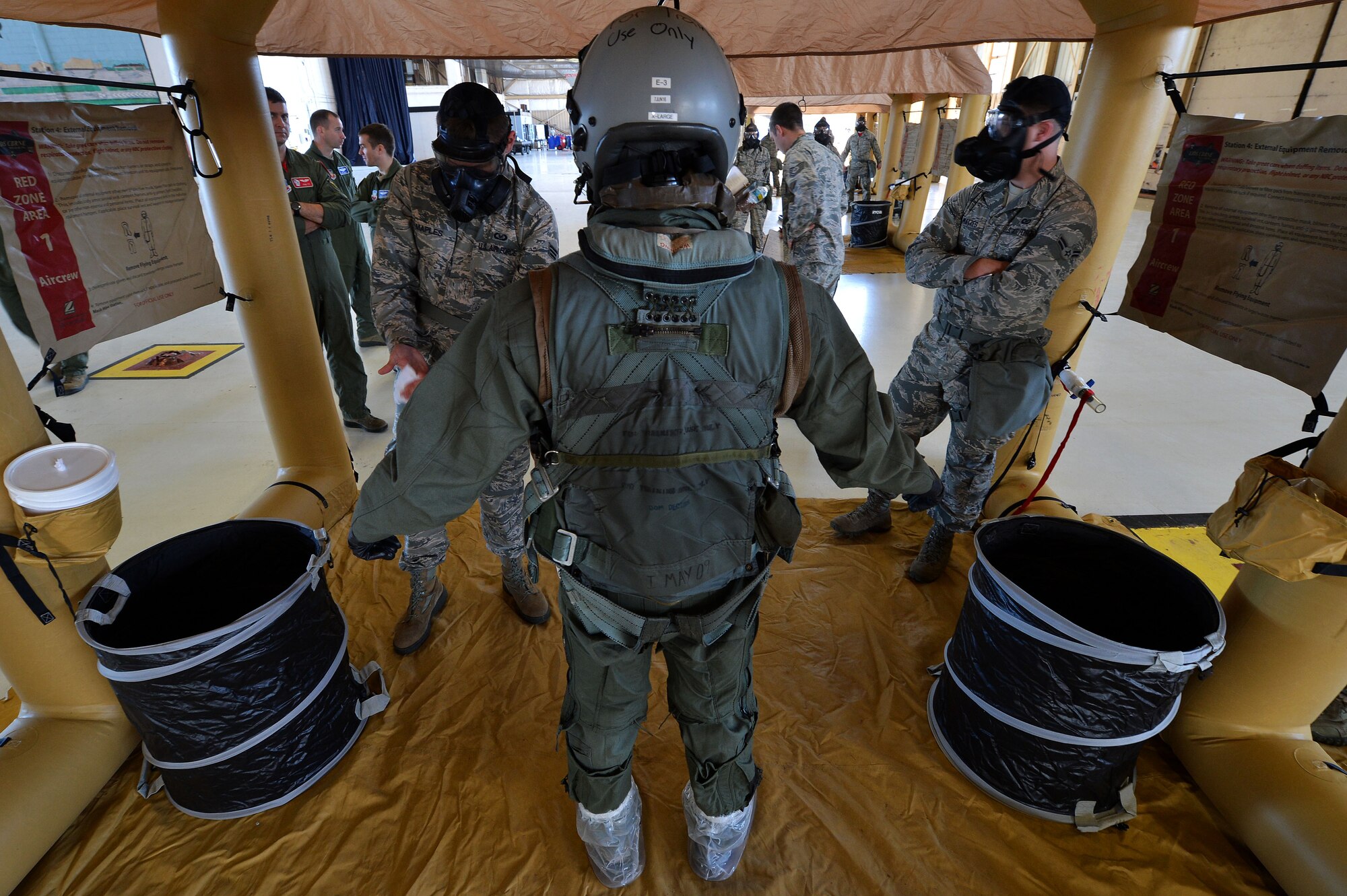 U.S. Air Force Airmen assigned to the 20th Operations Support Squadron mitigate a pilot during decontamination training at Shaw Air Force Base, S.C., Oct. 23, 2015. During the training, pilots and aircrew flight equipment Airmen practiced the actions they would take if a pilot became contaminated during flight. (U.S. Air Force photo by Senior Airman Michael Cossaboom)