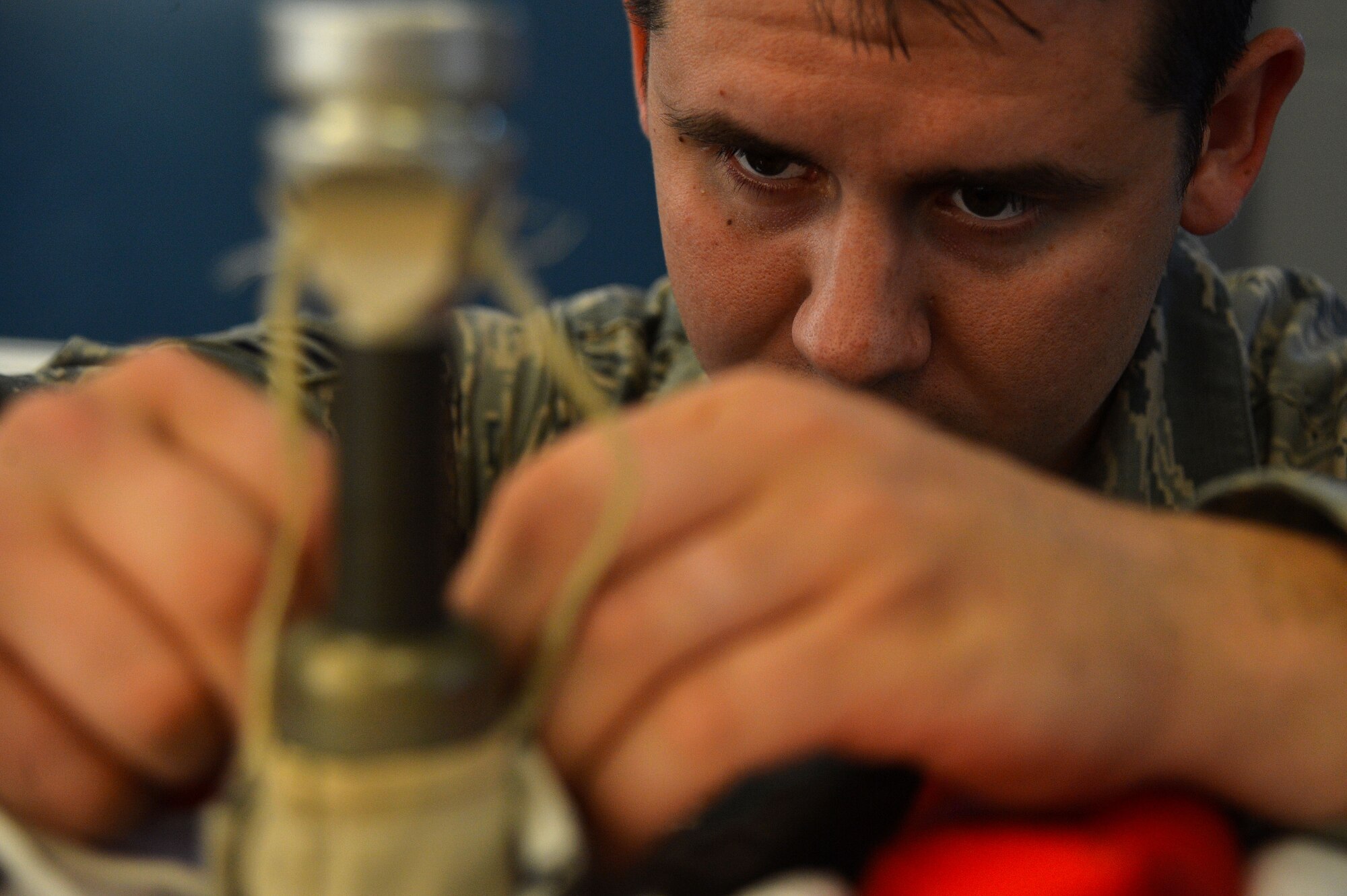 U.S. Air Force Senior Airman Kyle Burroughs, 20th Operations Support Squadron aircrew flight equipment specialist, secures a back-up firing lanyard to a mortar tube sleeve at Shaw Air Force Base, S.C., Oct. 20, 2015. The firing lanyards ensure proper deployment of the parachute canopy. (U.S. Air Force photo by Senior Airman Michael Cossaboom)
