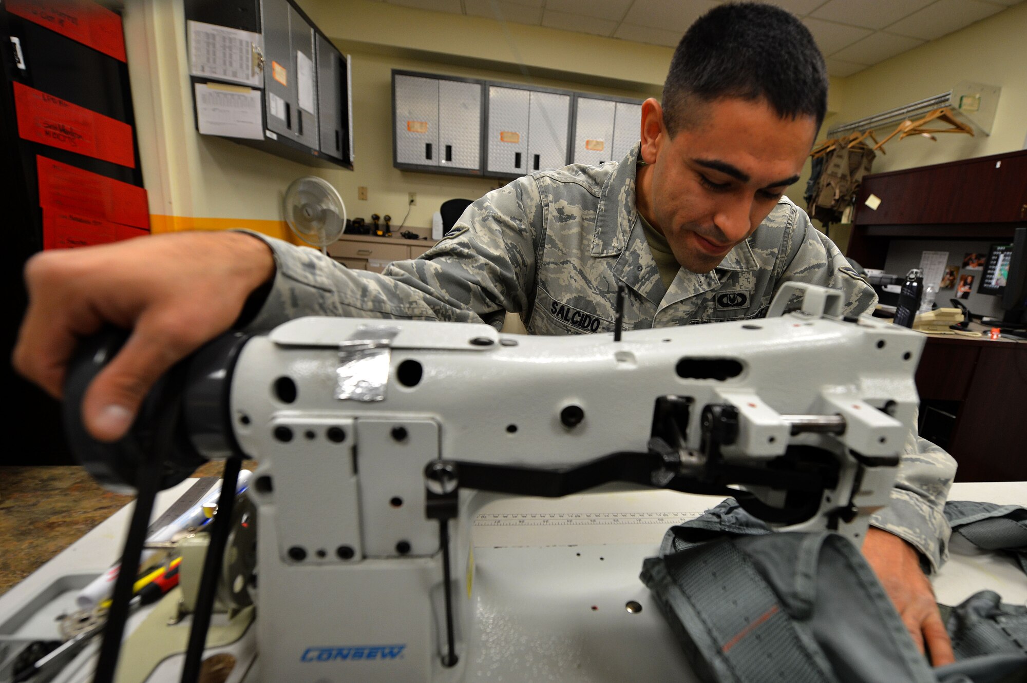U.S. Air Force Airman 1st Class Jerry Salcido, 20th Operations Support Squadron aircrew flight equipment specialist, sews a PCU-15B/P torso harness at Shaw Air Force Base, S.C., Oct. 21, 2015. AFE airmen inspect, maintain, and service all aircrew’s gear to ensure it is in working order and has no discrepencies. (U.S. Air Force photo by Senior Airman Michael Cossaboom)