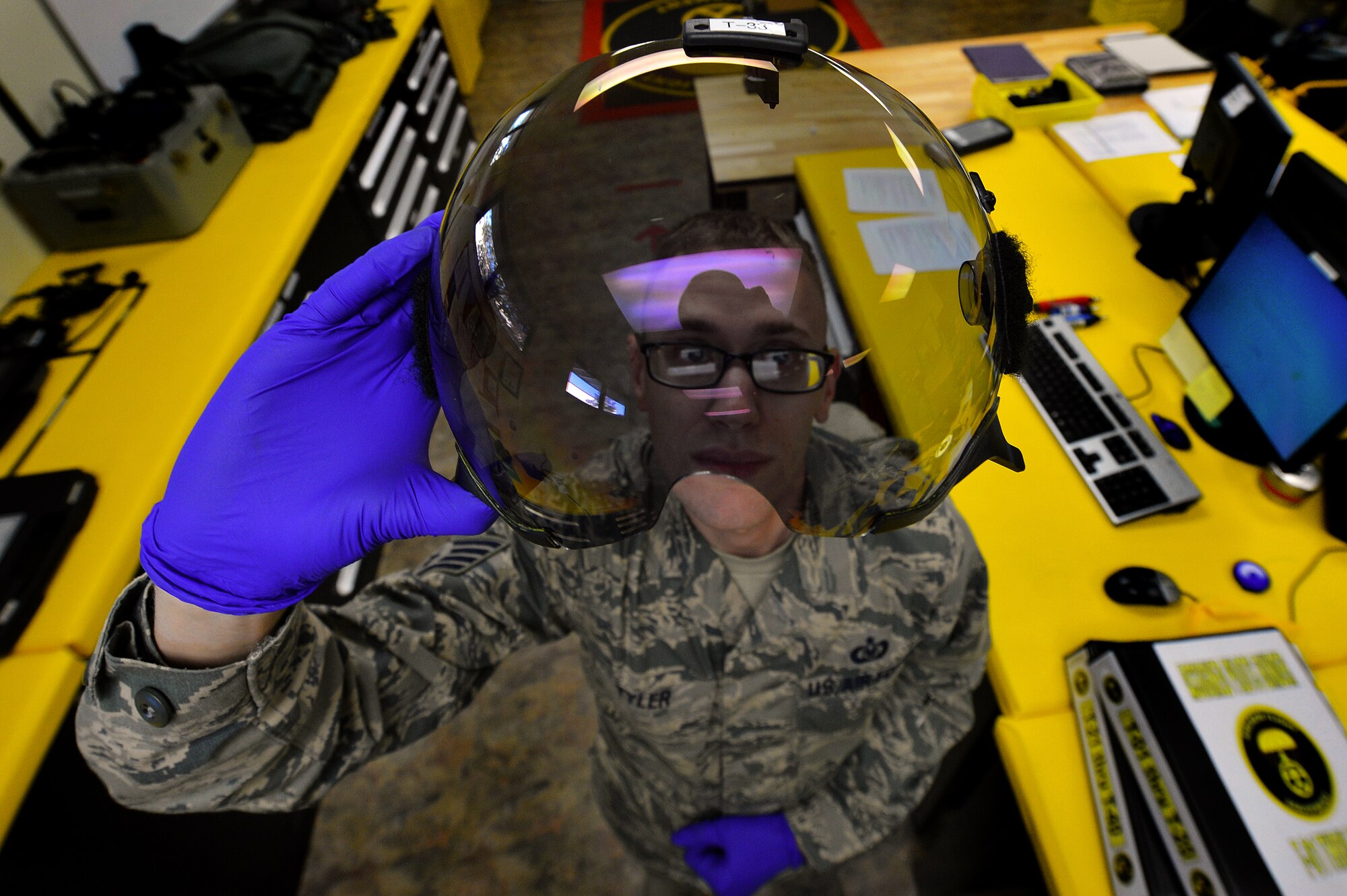 U.S. Air Force Staff Sgt. Anthony Tyler, 20th Operations Support Squadron aircrew flight equipment specialist, inspects the visor of a pilot’s helmet at Shaw Air Force Base, S.C., Oct. 21, 2015. Tyler has to inspect the visor for scratches and damage to ensure the pilots vision isn’t obscured during flight. (U.S. Air Force photo by Senior Airman Michael Cossaboom)