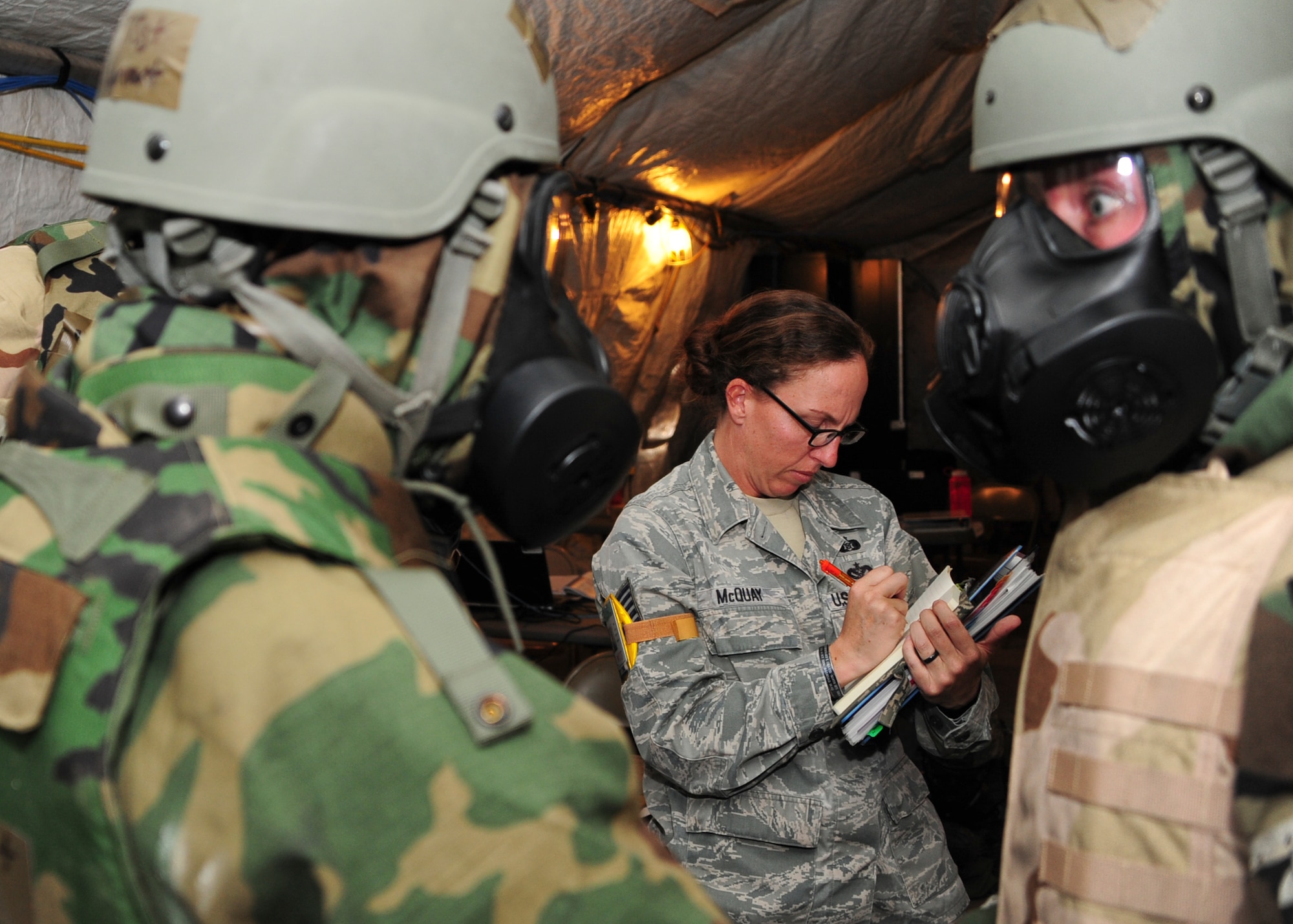 U.S. Air Force Tech. Sgt. Alicia McQuay, Wing Inspection Team member, observes Airmen responding to a simulated chemical attack during Exercise BUSHWHACKER 15-07 at Davis-Monthan Air Force Base, Ariz., Nov. 3, 2015. The Wing Inspection Team observed and graded how the 355th Fighter Wing handled and reacted to wartime scenarios. (U.S. Air Force photo by Airman Basic Nathan H. Barbour/Released)