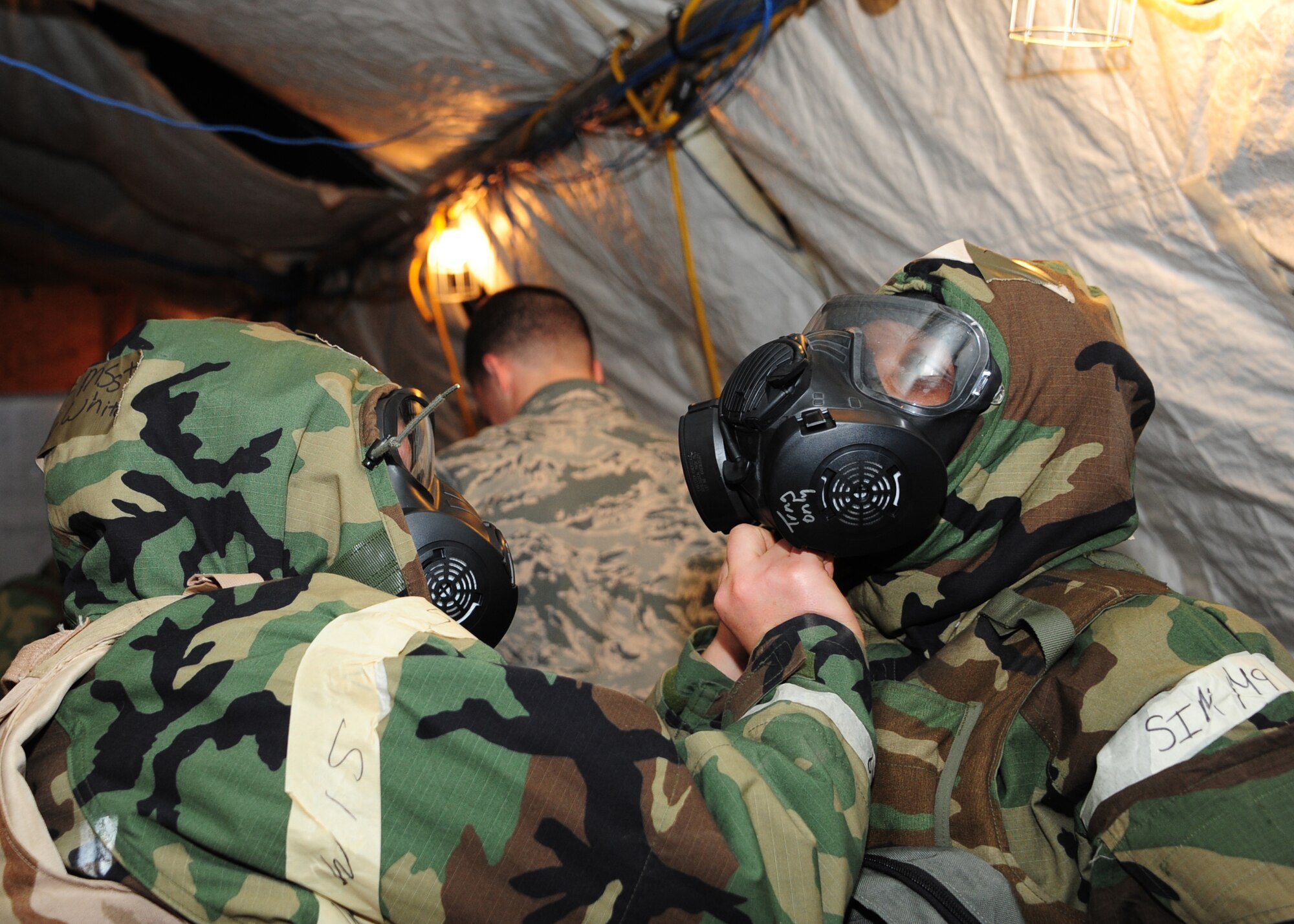 Two U.S Airmen perform buddy checks on each other’s mission oriented protective posture gear in response to a simulated chemical attack during Exercise BUSHWHACKER 15-07 at Davis-Monthan Air Force Base, Ariz., Nov. 3, 2015. The Wing Inspection Team observed and graded how the 355th Fighter Wing handled and reacted to wartime scenarios. (U.S. Air Force photo by Airman Basic Nathan H. Barbour/Released)
