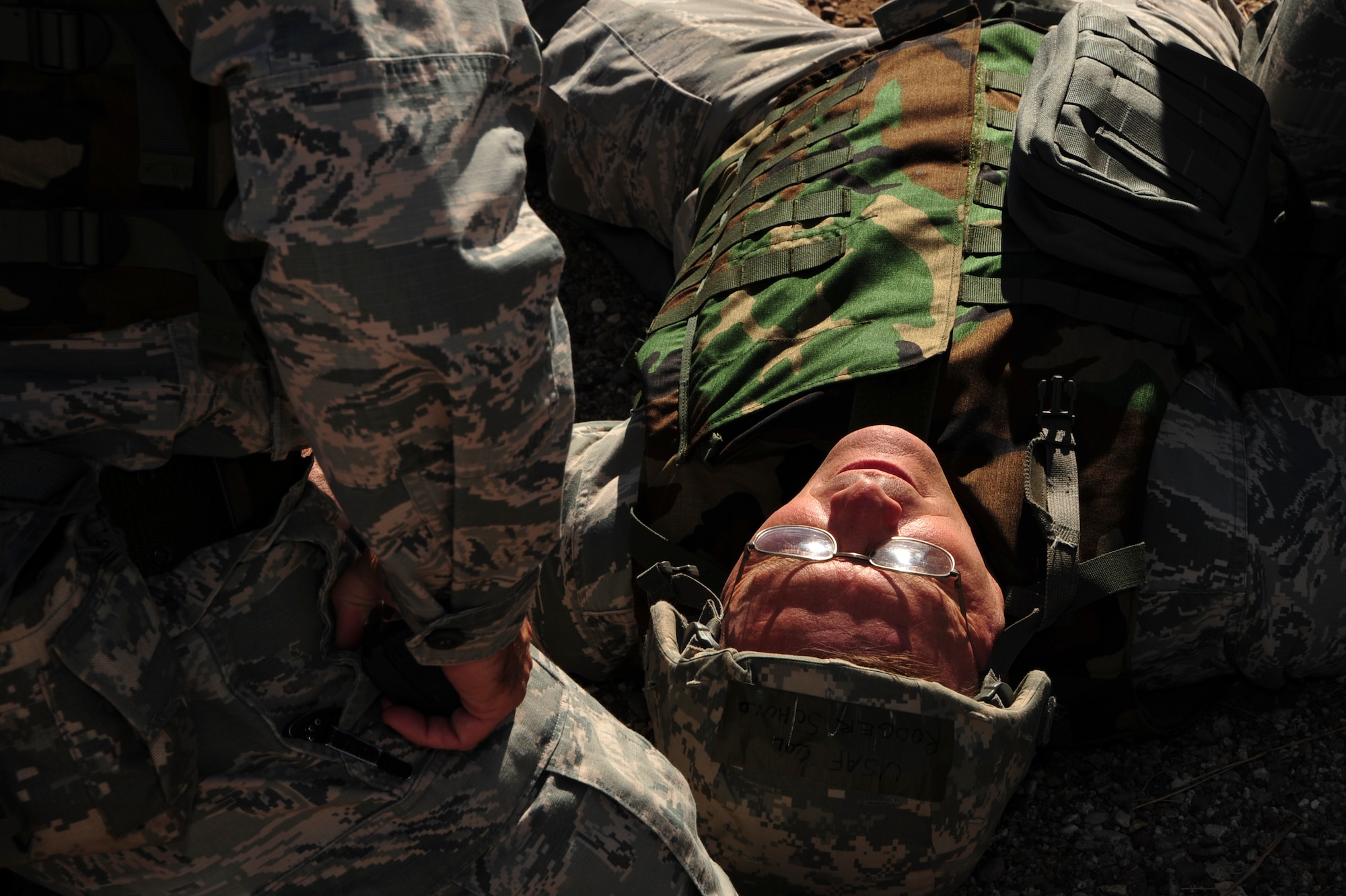 U.S. Air Force Col. Rodger Schuld, 355th Mission Support Group commander, tests Airmen’s readiness by simulating a fatal heart attack during Exercise BUSHWHACKER 15-07 at Davis-Monthan Air Force Base, Ariz., Nov. 3, 2015. The Wing Inspection Team observed and graded how the 355th Fighter Wing handled and reacted to wartime scenarios. (U.S. Air Force photo by Airman Basic Nathan H. Barbour/Released)