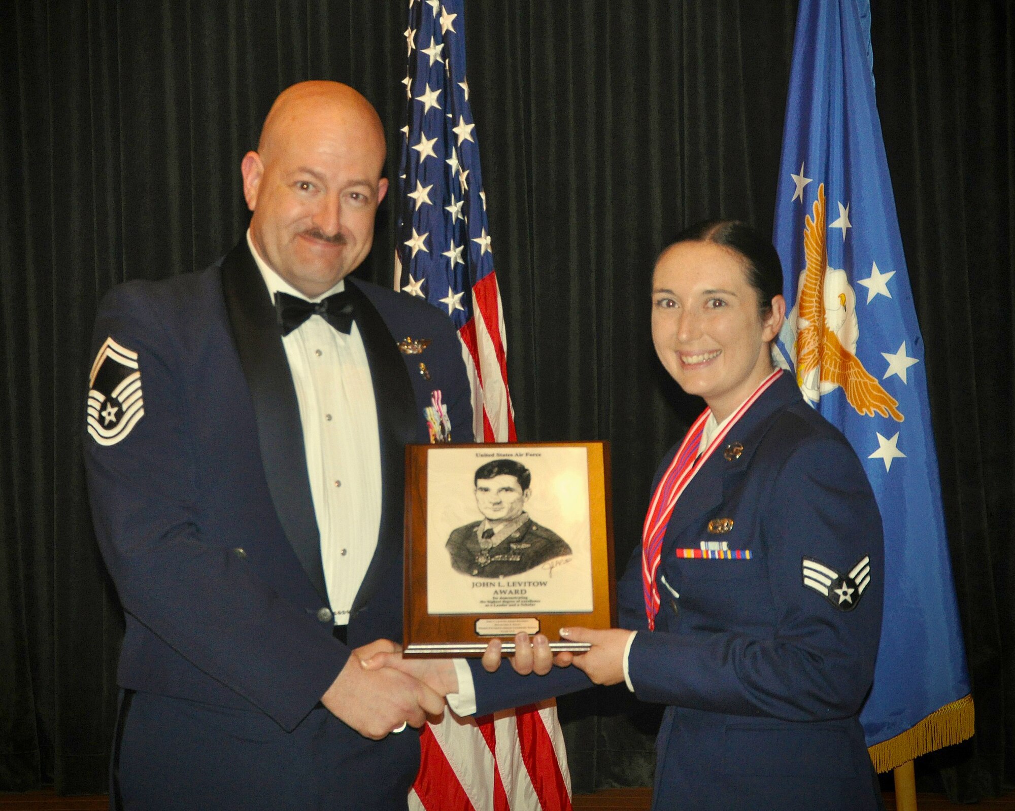 WRIGHT-PATTERSON AIR FORCE BASE, Ohio - Senior Master Sgt. David McCoy, President, Air Force Sergeants Association, Kittyhawk Chapter 751, presents Senior Airman Alyssa Wanless, 445th Aircraft Maintenance Squadron aircraft guidance and control system journeyman, with the John L. Levitow Award at the Airman Leadership School graduation  Oct. 8, 2015. This award goes to the student who demonstrates overall superior performance while attending. It denotes both academic and leadership excellence, and is the highest honor bestowed upon a graduate of an enlisted professional military education program. AFSA sponsors the Levitow Award for the Wright-Patt Airman Leadership School. (Photo courtesy of Senior Airman Daniel Perrault)