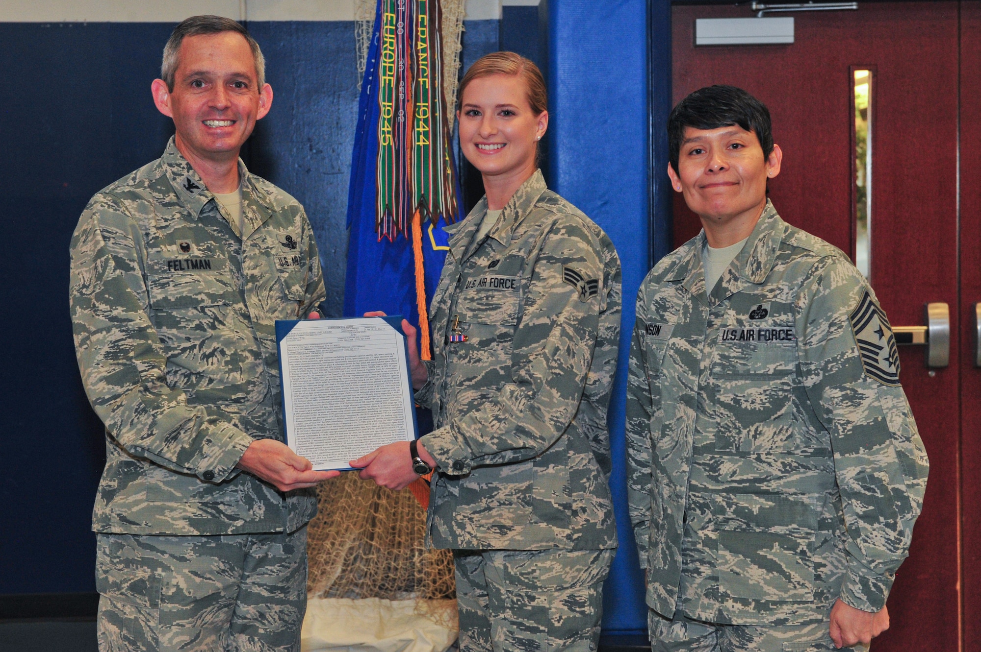 Air Force Reservists Col. Damon S. Feltman (left) and Chief Master Sgt. Imelda B. Johnson (right) pose with Senior Airman Cortney S. Kelly (center) who was presented an Outstanding Unit Award on behalf of the 310th Space Wing during the 310th SW Commander's Call, Saturday, Nov. 7, 2015, Schriever Air Force Case, Colo. Feltman is the 310th SW commander, and Johnson is the wing's command chief
(U.S. Air Force photo/Tech. Sgt. Nicholas B. Ontiveros)