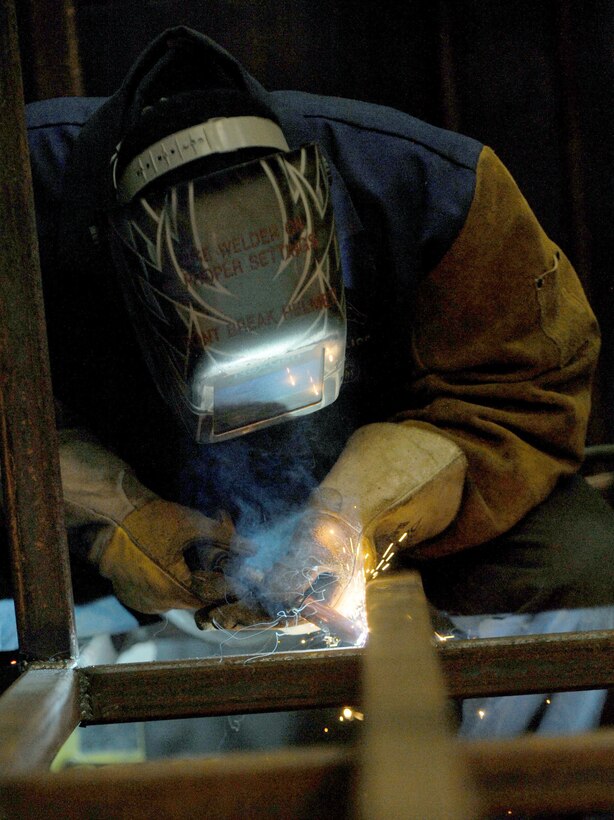 Airman 1st Class Jordan McCollum, 28th Logistics Readiness Squadron vehicle maintenance journeyman, welds two metal bars to create a storage rack for B-1 bomber tires at Ellsworth Air Force Base, S.D., Nov. 3, 2015. The storage rack ensures each $40,000 tire is secured and remains serviceable. (U.S. Air Force photo by Airman Sadie Colbert/Released)