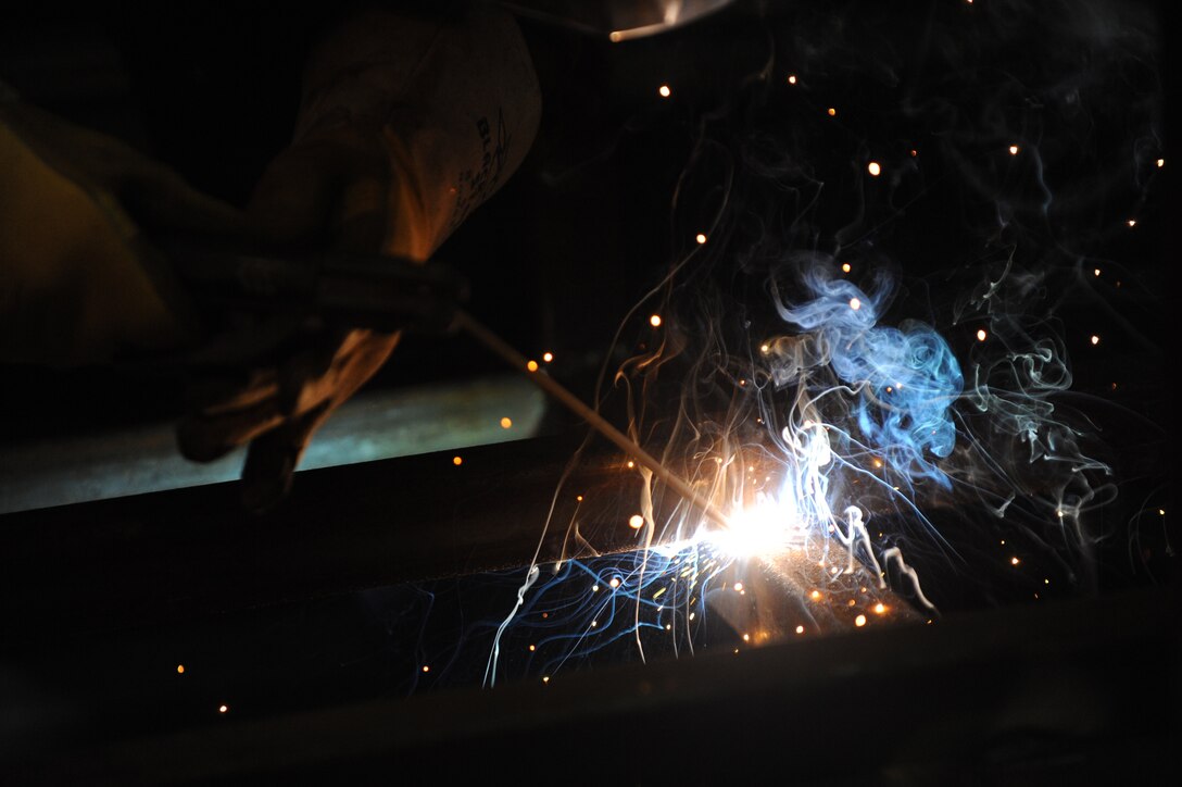 Staff Sgt. Antony Roubal, 28th Logistics Readiness Squadron vehicle maintenance supervisor, welds two metal bars together with a fill rod at Ellsworth Air Force Base, S.D., Nov. 3, 2015. The welding gun uses a rod to combine argon and carbon dioxide during the welding process. (U.S. Air Force photo by Airman Sadie Colbert/Released)
