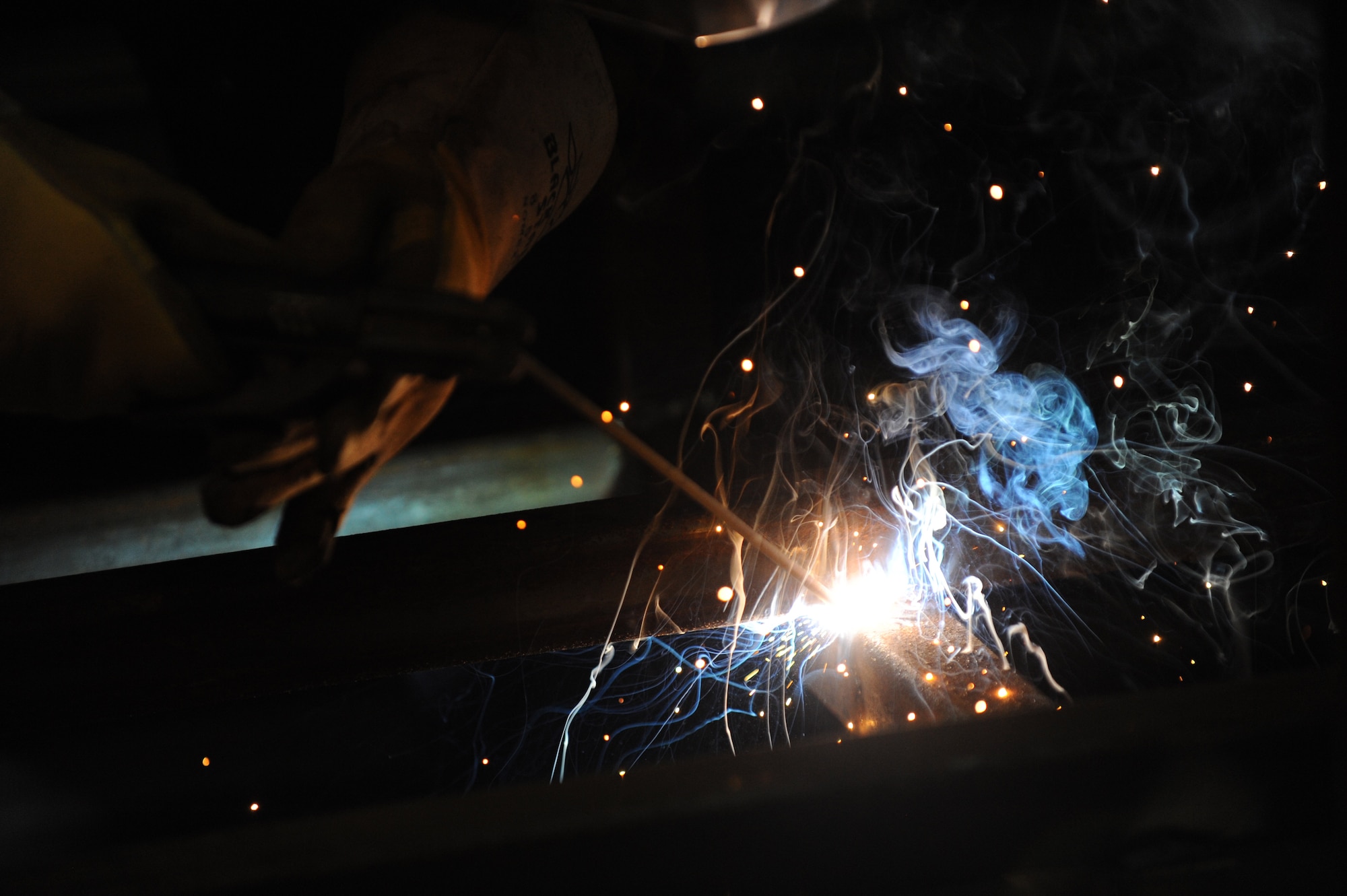 Staff Sgt. Antony Roubal, 28th Logistics Readiness Squadron vehicle maintenance supervisor, welds two metal bars together with a fill rod at Ellsworth Air Force Base, S.D., Nov. 3, 2015. The welding gun uses a rod to combine argon and carbon dioxide during the welding process. (U.S. Air Force photo by Airman Sadie Colbert/Released)