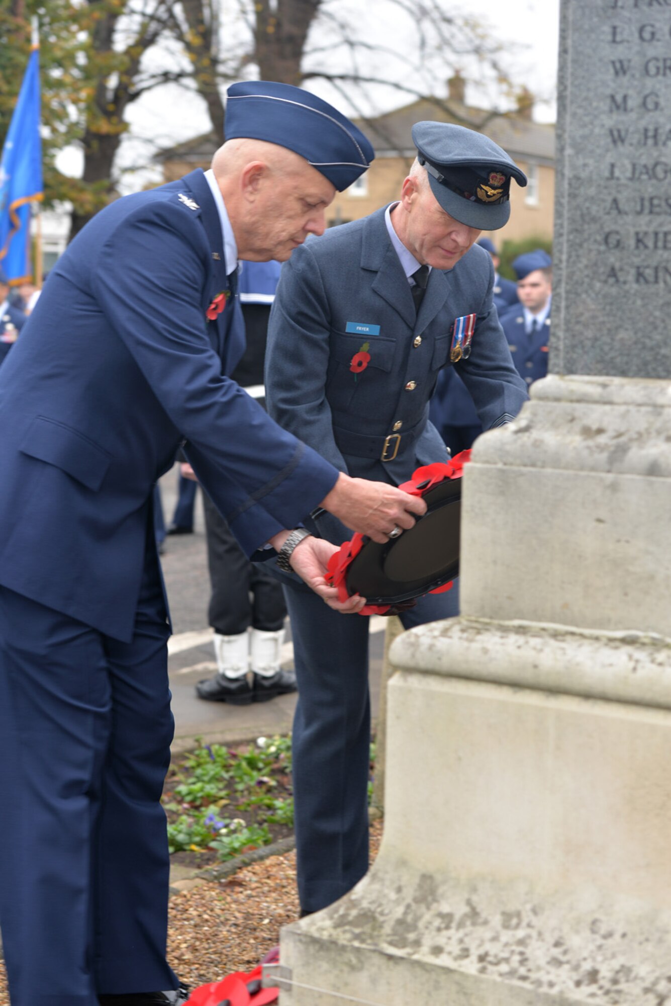 U.S. Air Force Col. Kelly Scott, left, 100th Maintenance Group commander, and Royal Air Force Sqdn. Ldr. Richard Fryer, RAF commander RAF Mildenhall, lay a poppy wreath during a Remembrance Day ceremony Nov. 8, 2015, in Mildenhall, Suffolk, England. The poppy was chosen as the symbol of remembrance because many British soldiers lost their lives in the poppy fields of Flanders, Belgium, during World War I. (U.S. Air Force photo by Karen Abeyasekere/Released)