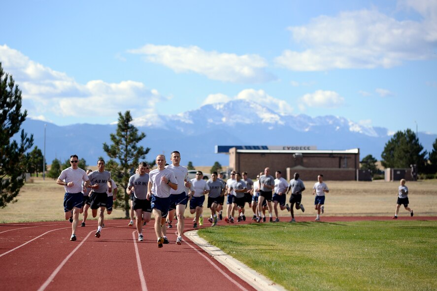 Military members run a 1,000 meter sprint during a German Air Force Proficiency Badge competition Tuesday, Oct. 27, 2015, at Schriever Air Force Base, Colorado. The GAFPB consists of a variety of components including: first aid and Mission Oriented Protective Posture tasks/evaluation, 11x10 meter sprint test, chin-up test, 1,000 meter run, 100 meter swim in full uniform, ruck-march and marksmanship event. (U.S. Air Force photo/Christopher DeWitt)