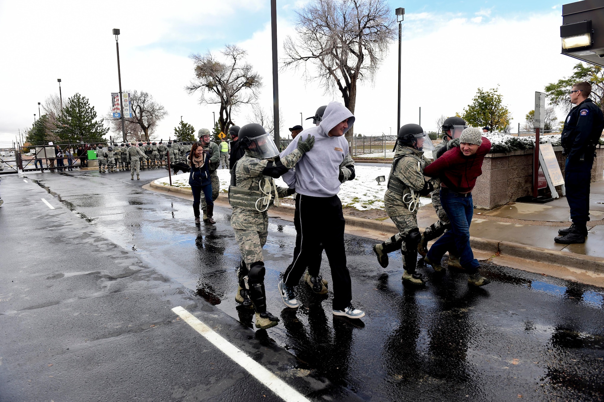 Members of a the 460th Security Force Squadron detain two mock protesters during the Panther Lightning exercise Nov. 5, 2015, at the 6th Avenue Gate on Buckley Air Force Base, Colo. The protest was added as a local scenario to the U.S. Strategic Command exercise, Global Lightning, which bases participated in to increase preparedness and the ability to respond to a threat. (U.S. Air Force photo by Senior Airman Phillip Houk/Released)