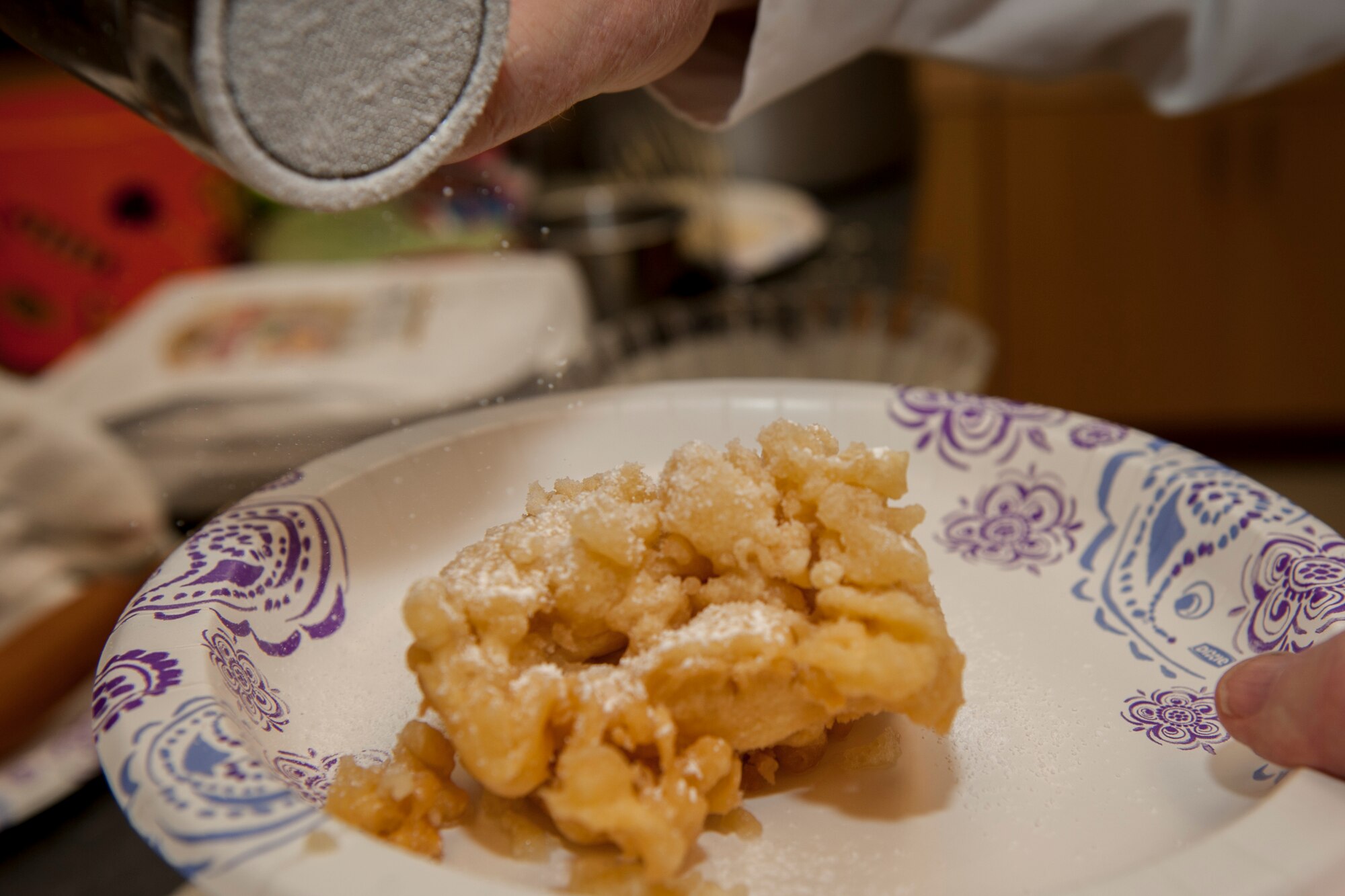 PETERSON AIR FORCE BASE, Colo. - A volunteer shakes powdered sugar onto a fresh funnel cake at the Peterson Chapel's fair food event Nov. 5, 2015. Families enjoyed many types of food found at most fairs, including corn dogs, french fries and cotton candy. (U.S. Air Force photo by Senior Airman Rose Gudex)