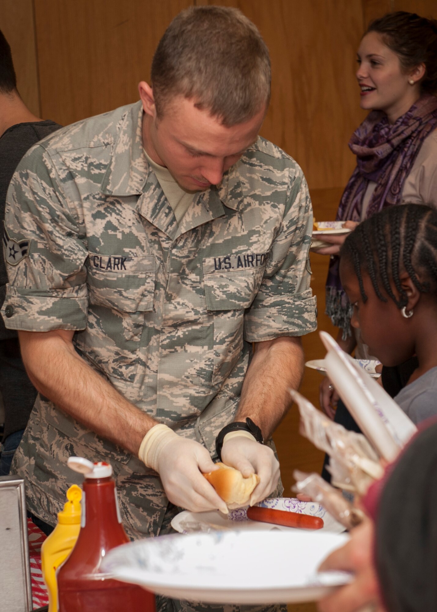PETERSON AIR FORCE BASE, Colo. - Airman 1st Class Benjamin Clark, 21st Aerospace Medical Squadron, passes out hot dogs to those in line during the Peterson Chapel's fair food event Nov. 5, 2015. Food available included hot dogs, corn dogs, french fries, funnel cakes, cotton candy and other goodies found at most fairs. (U.S. Air Force photo by Senior Airman Rose Gudex)