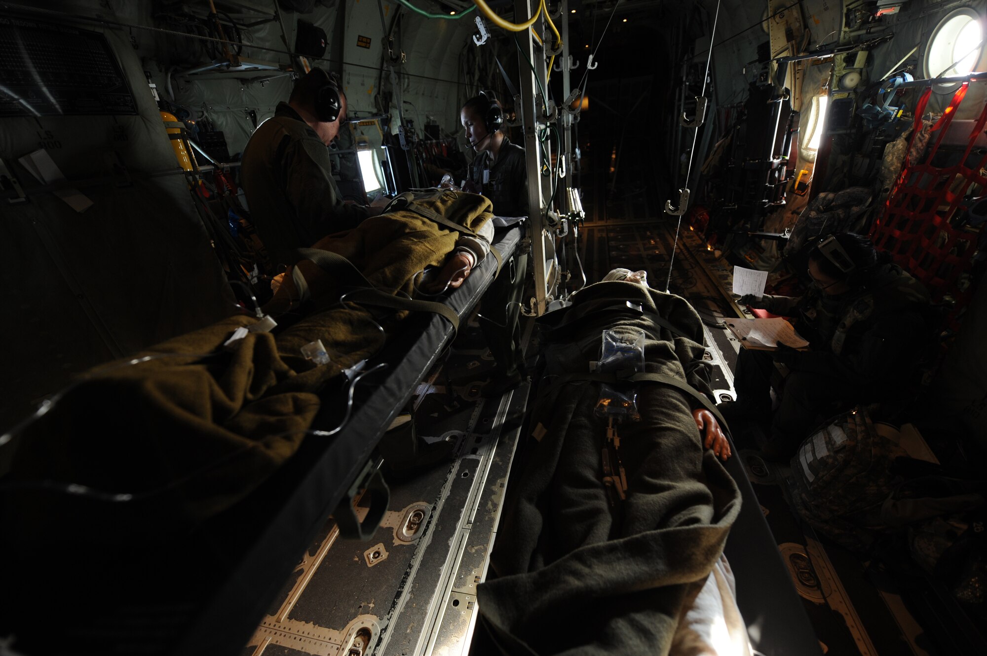Airmen participating in GREEN FLAG Little Rock 16-02 assess simulated patients during an aeromedical evacuation mission Nov. 4, 2015, near Fort Polk, La. The team read scenarios and treated injuries of the patients as needed while overcoming turbulence and a high level of noise. (U.S. Air Force photo by Senior Airman Scott Poe)