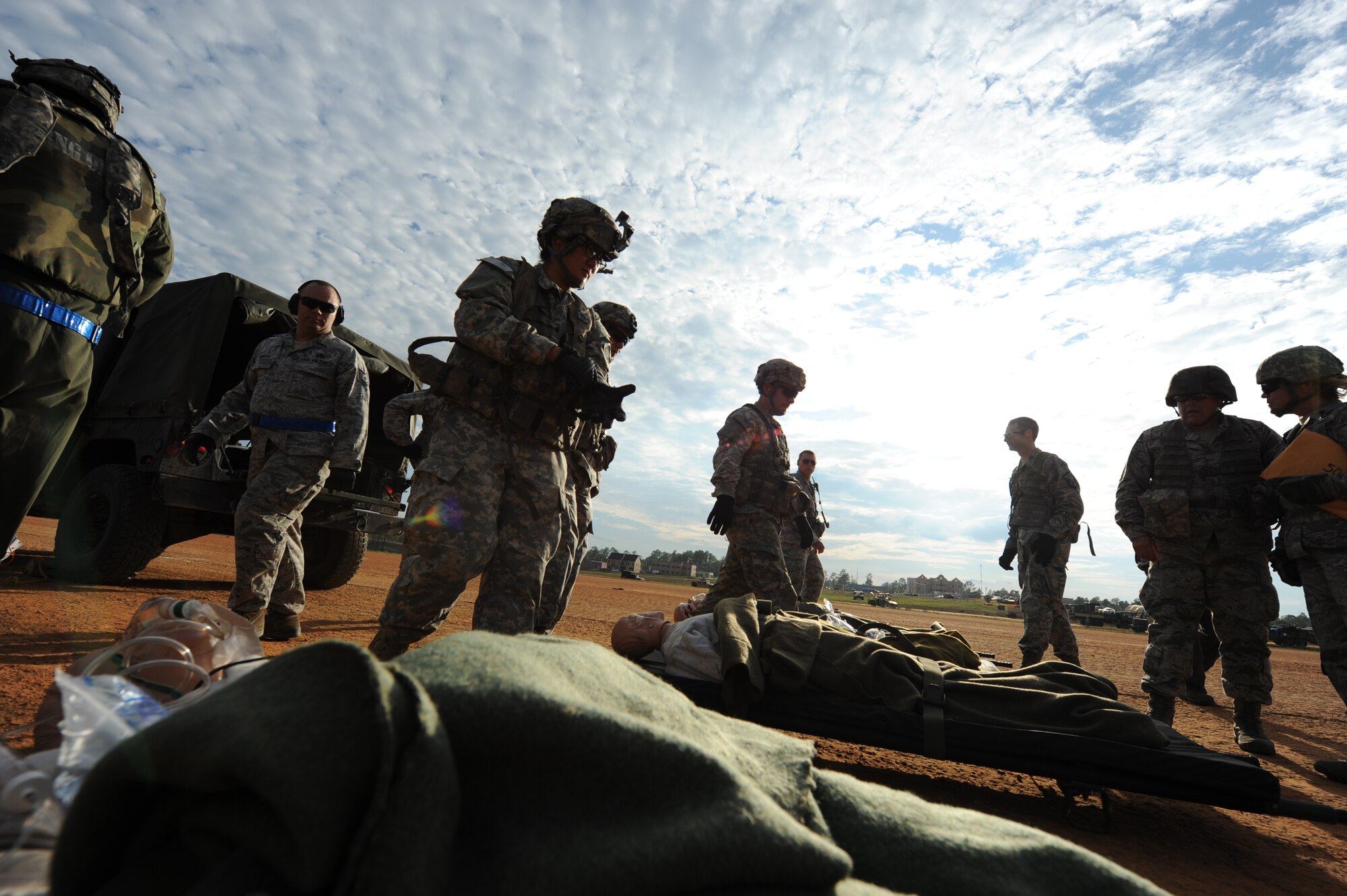 Airmen and soldiers participating in GREEN FLAG Little Rock 16-02 prepare to load simulated casualties onto a C-130J Nov. 4, 2015, at Fort Polk, La. Using their self-aid buddy-care training, teams of two lifted, carried and placed the patients strapped to litters onto the aircraft stanchions. (U.S. Air Force photo by Senior Airman Scott Poe)