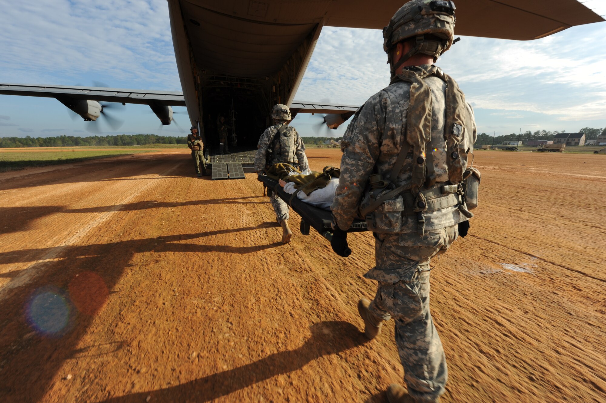 Soldiers from the 1st Brigade Combat Team, 82nd Airborne Division, carry a litter to a C-130J during aeromedical evacuation training Nov. 4, 2015, at Fort Polk, La. To ensure rapid medical response, the mission was conducted with engines running. (U.S. Air Force photo by Senior Airman Scott Poe)