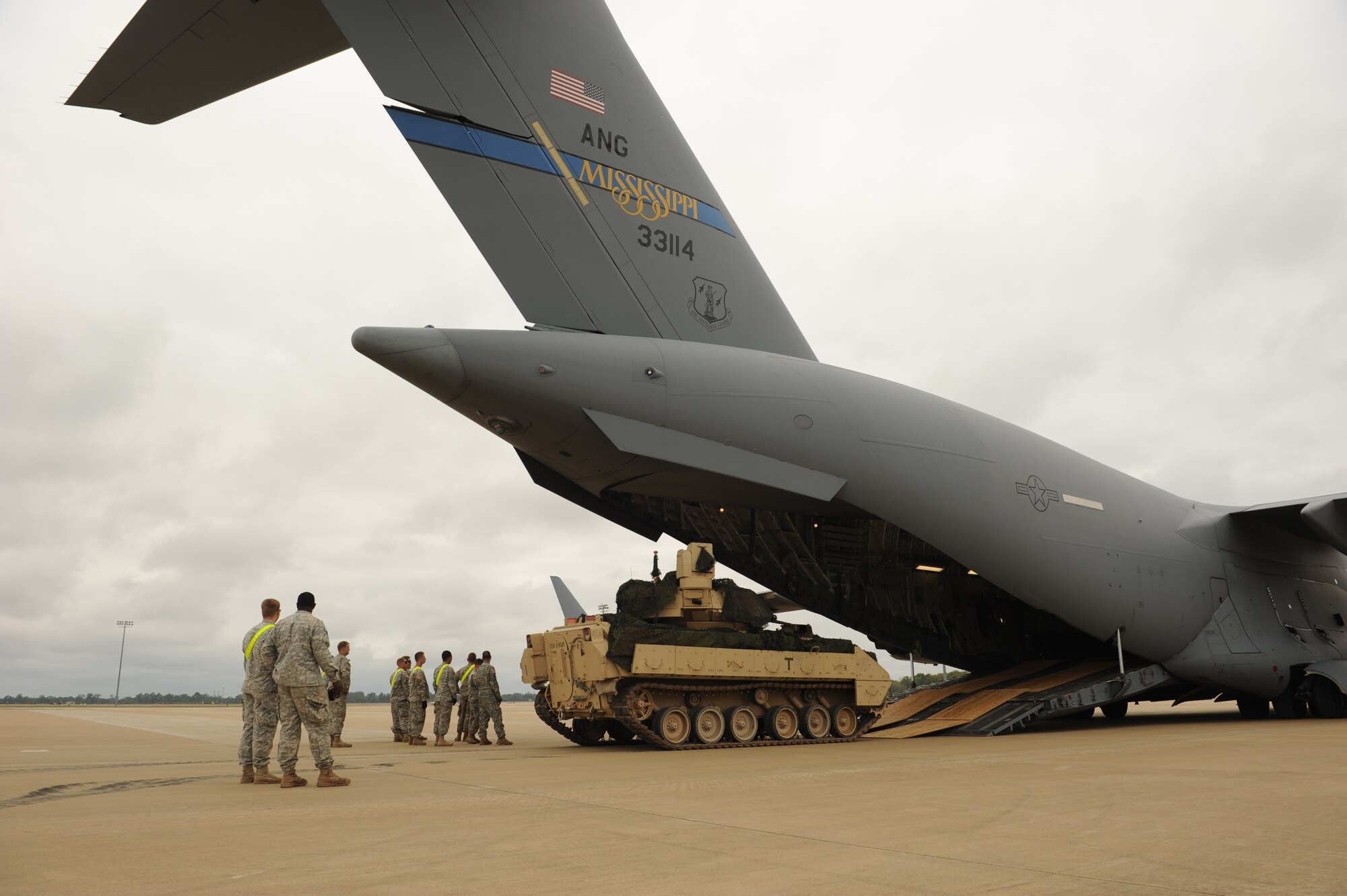 Airmen and soldiers participating in GREEN FLAG Little Rock 16-02 observe and guide an M2 Bradley tank onto a C-17 Globemaster III Nov. 3, 2015, at Alexandria, La. The two sister services worked together to load a tank that many of them had never loaded but is a common movement in deployed locations. (U.S. Air Force photo by Senior Airman Scott Poe) 