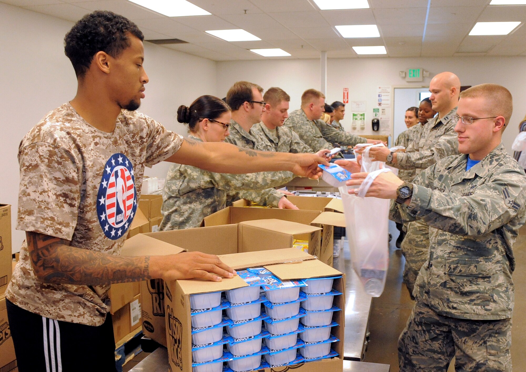 Trey Burke, Utah Jazz point guard, and Airman 1st Class Brian Shimchick, 729th Air Control Squadron, sort donated food items during a service project called “Commitment to Service” in Salt Lake City, Utah, Friday, Nov. 6, 2015. In honor of Veterans Day, Jazz players, Orbital ATK executives, local military personnel and the Utah Food Bank sorted food and packed backpacks with nutritious items meant to benefit children in the community. (US Air Force photo by Todd Cromar/Released)