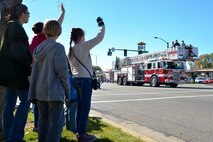 A Hill Air Force Base fire truck passes waving crowds during the annual Veterans Day parade in Ogden, Utah, Nov. 7, 2015. Airmen and equipment from the base participated in the annual event held on Washington St. in downtown Ogden. (U.S. Air Force photo by R. Nial Bradshaw/Released)