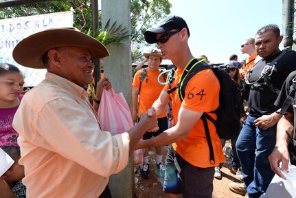U.S. Air Force Lt. Col. James Trachier, deputy commander Joint Task Force Bravo, hands a local man a bag of food and supplies during Chapel Hike 64, Comayagua, Honduras, Oct. 31, 2015. Chapel Hikes take place every six weeks and provide community outreach by bringing much needed food and supplies to the less fortunate. (U.S. Air Force photo by Senior Airman Westin Warburton/Released)