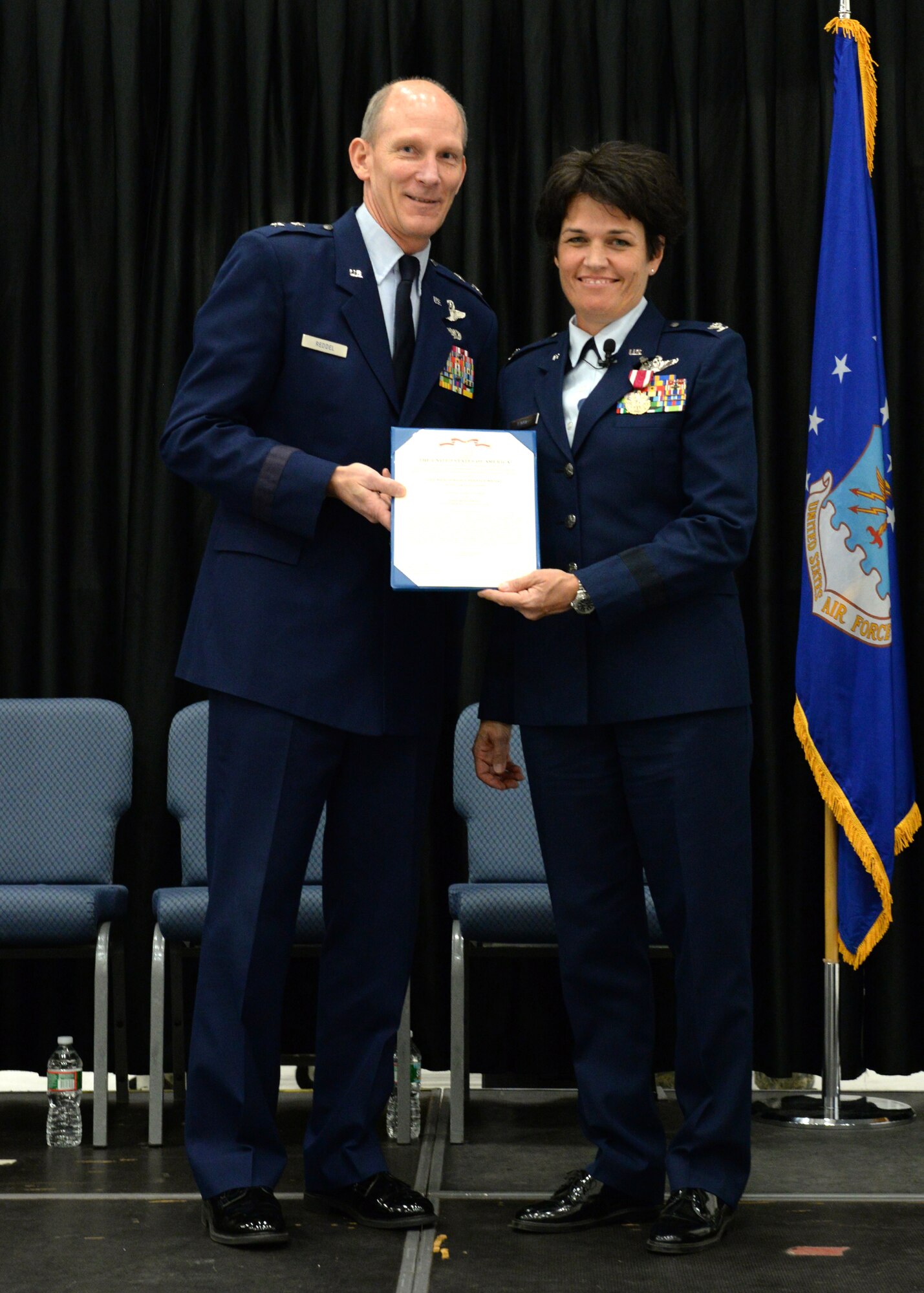 The Adjutant General Maj. Gen. William N. Reddel III presents Brig. Gen. Laurie Farris a Meritorious Service Medal certificate following a medal presentation at Pease Air National Guard Base, New Hampshire Nov. 7. Farris was promoted to brigadier general during the ceremony. She has been assigned as the N.H. ANG chief of staff responsible for the direction and coordination of staff activities for Joint Force Headquarters. (U.S. Air National Guard photo by Senior Airman Kayla McWalter)