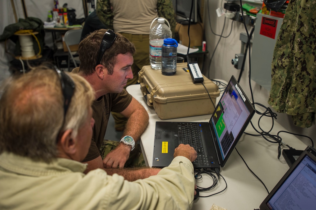 U.S. Navy Petty Officer 1st Class Neal Lelievre, center, and Robert Stitt, a fleet support representative, monitor the status of an unmanned underwater vehicle during Exercise Clear Horizon 2015 on Commander Fleet Activities Chinhae, South Korea, Nov. 5, 2015. Lelievre is a mineman assigned to Mobile Unit 1. U.S. Navy photo by Petty Officer 2nd Class Daniel Rolston)