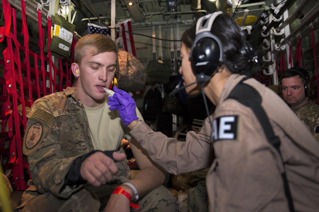 U.S. Air Force Tech. Sgt. Audrey Belmonte checks the vitals of airman 1st Class Spencer Brendal during a medevac mission flight en route to Al Udeid Air Base, Qatar, Nov. 6, 2015. Belmonte is a medical technician assigned to the 455th Expeditionary Aeromedical Evacuation Squadron and Brendal is an avionics technician assigned to the 455th Expeditionary Aircraft Maintenance Squadron. U.S. Air Force photo by Tech. Sgt. Robert Cloys