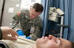 Army National Guard Sgt. Gerald Dick, a combat medic assigned to the Troop Medical Clinic at Camp Atterbury Joint Maneuver Training Center, Ind., administers an intravenous line to a Soldier here Dec. 14, 2011. Dick, a licensed practical nurse and case manager at Camp Atterbury, is "always" on duty and has rendered medical assistance during to two separate vehicle accidents earlier this year while not on duty.
