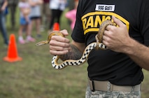 Staff Sgt. Gusti, 6th Range Training Battalion, shows the crowd a nonvenomous snake during the Duke Field Wing Day event Nov. 7.  The 919th Special Operations Wing sets aside a special day each year to show appreciation for its reservists and their family members. Events included music, sports, children’s games, etc. (U.S. Air Force photo/Tech. Sgt. Jasmin Taylor)
