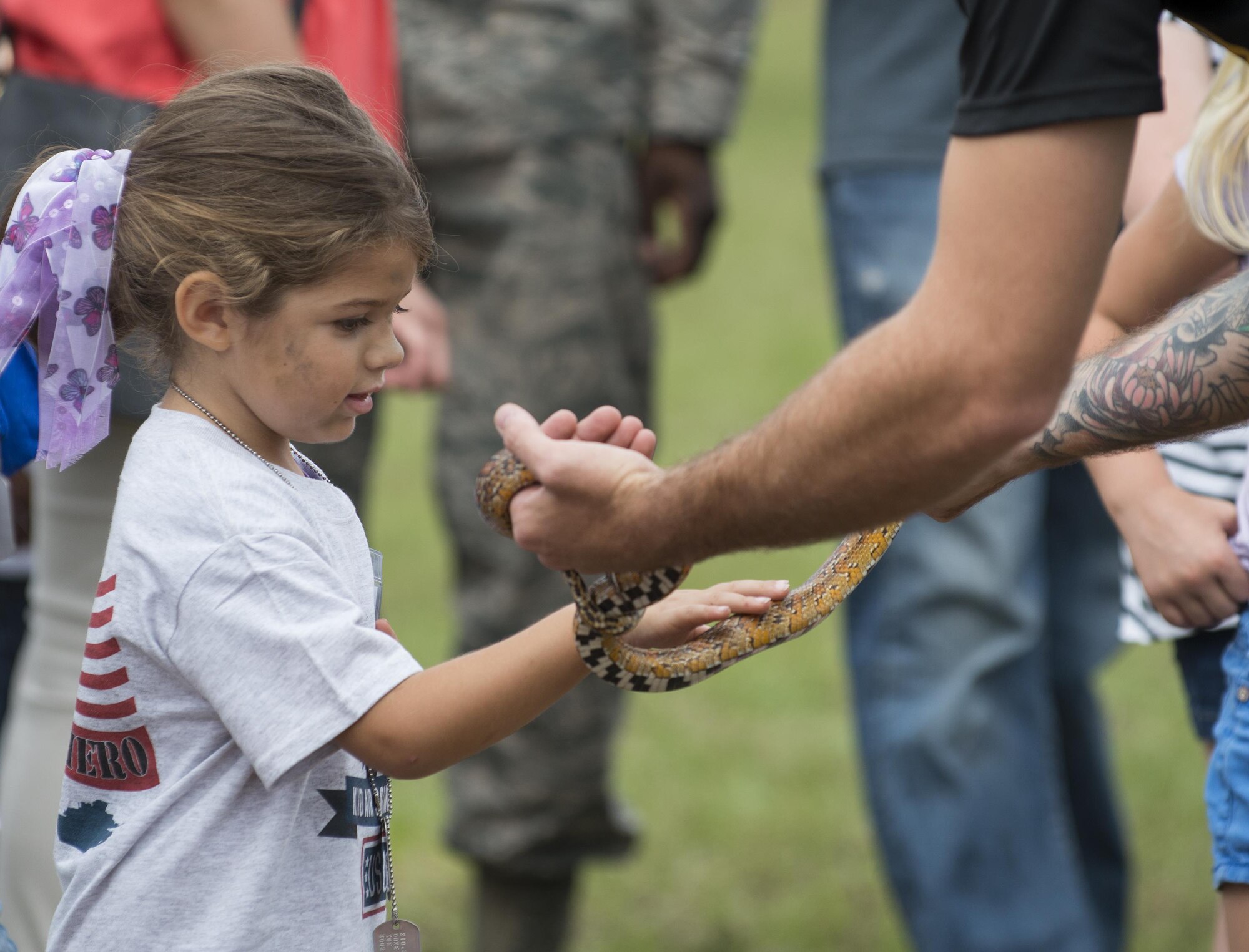 A kid pets a nonvenomous snake during the Duke Field Wing Day event Nov. 7.  The 919th Special Operations Wing sets aside a special day each year to show appreciation for its reservists and their family members. Events included music, sports, children’s games, etc. (U.S. Air Force photo/Tech. Sgt. Jasmin Taylor)