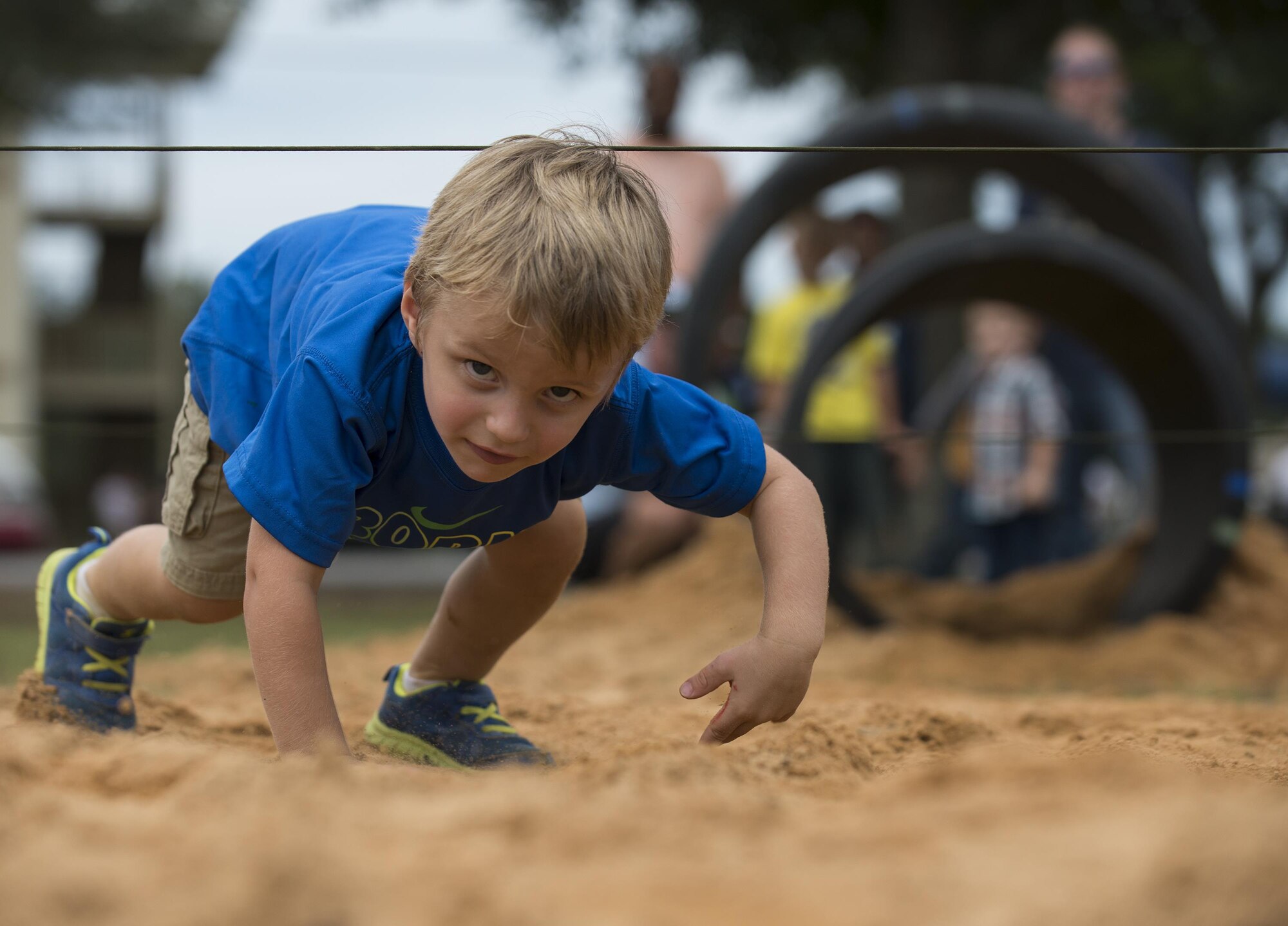 Gavin Sutphen low crawls through the obstacle course during the Duke Field Wing Day event Nov. 7.  The 919th Special Operations Wing sets aside a special day each year to show appreciation for its reservists and their family members. Events included music, sports, children’s games, etc. (U.S. Air Force photo/Tech. Sgt. Jasmin Taylor)