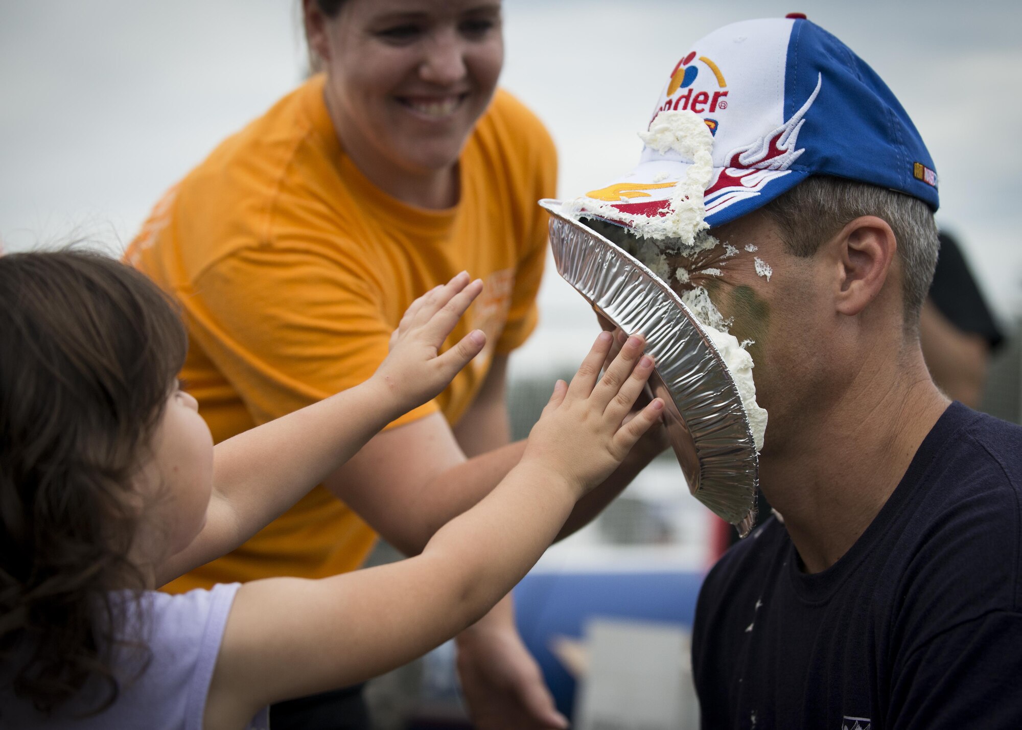 Peyton Roszkowski throws a pie in Col. Robert Bruckner, 919th Special Operations Wing Vice commander during the Duke Field Wing Day event Nov. 7.  The 919th SOW sets aside a special day each year to show appreciation for its reservists and their family members. Events included music, sports, children’s games, etc. (U.S. Air Force photo/Tech. Sgt. Jasmin Taylor)